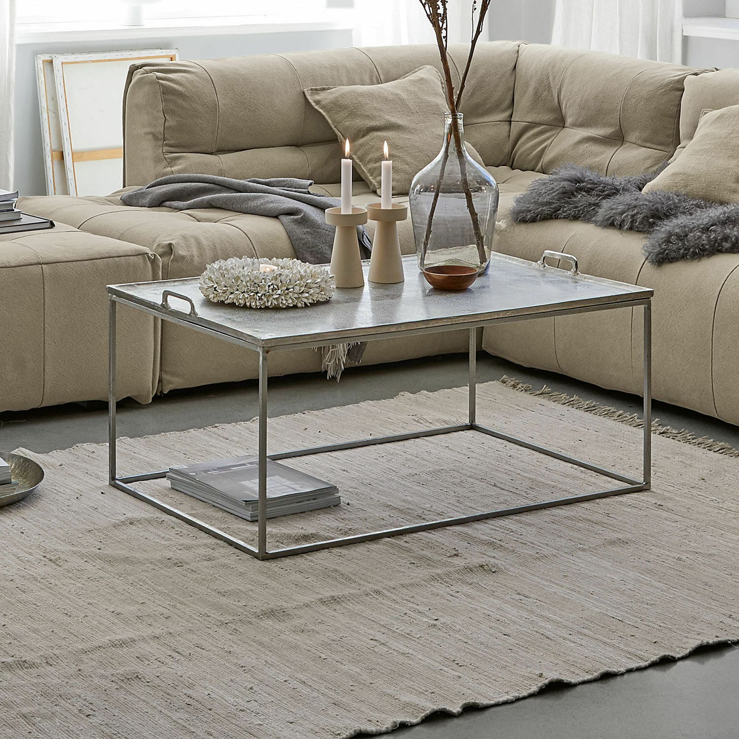 Table basse Bellingham Table basse avec cadre métallique et plateau argenté sur tapis beige dans un salon moderne