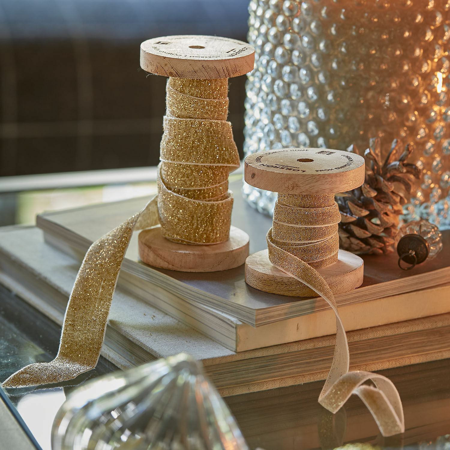 Fluwelen lint set van 2 Risorio Houten spoelen met glinsterend gouden decoratief lint op tafel met boeken en glazen decoraties