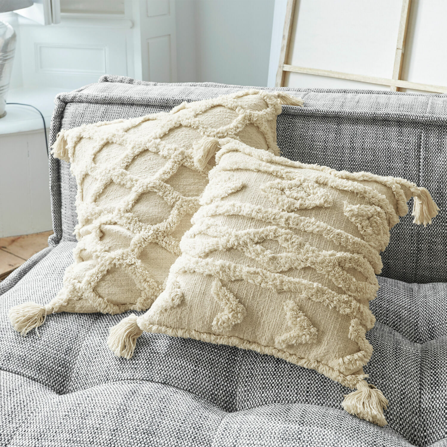 Kussenhoes set van 2 Linares Beige katoenen sierkussens met franjes en textuurpatronen op grijze gestoffeerde bank