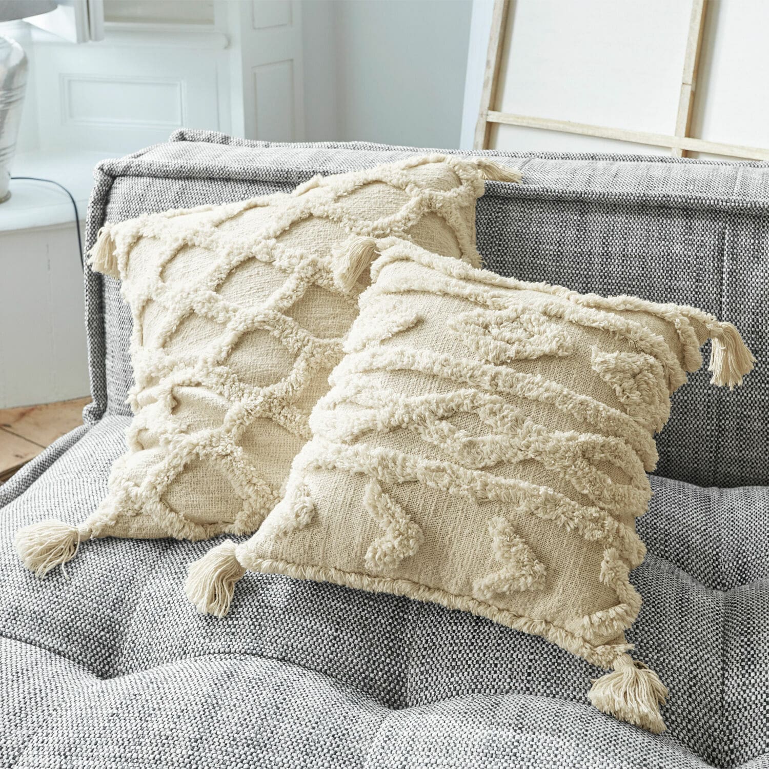 Kussenhoes set van 2 Linares Beige katoenen sierkussens met franjes en textuurpatronen op grijze gestoffeerde bank