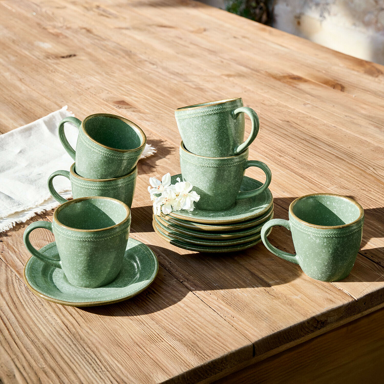Kopje met schoteltje set van 6 Norrvik Set groene keramische kopjes en schotels op houten tafel met bloem, servies set