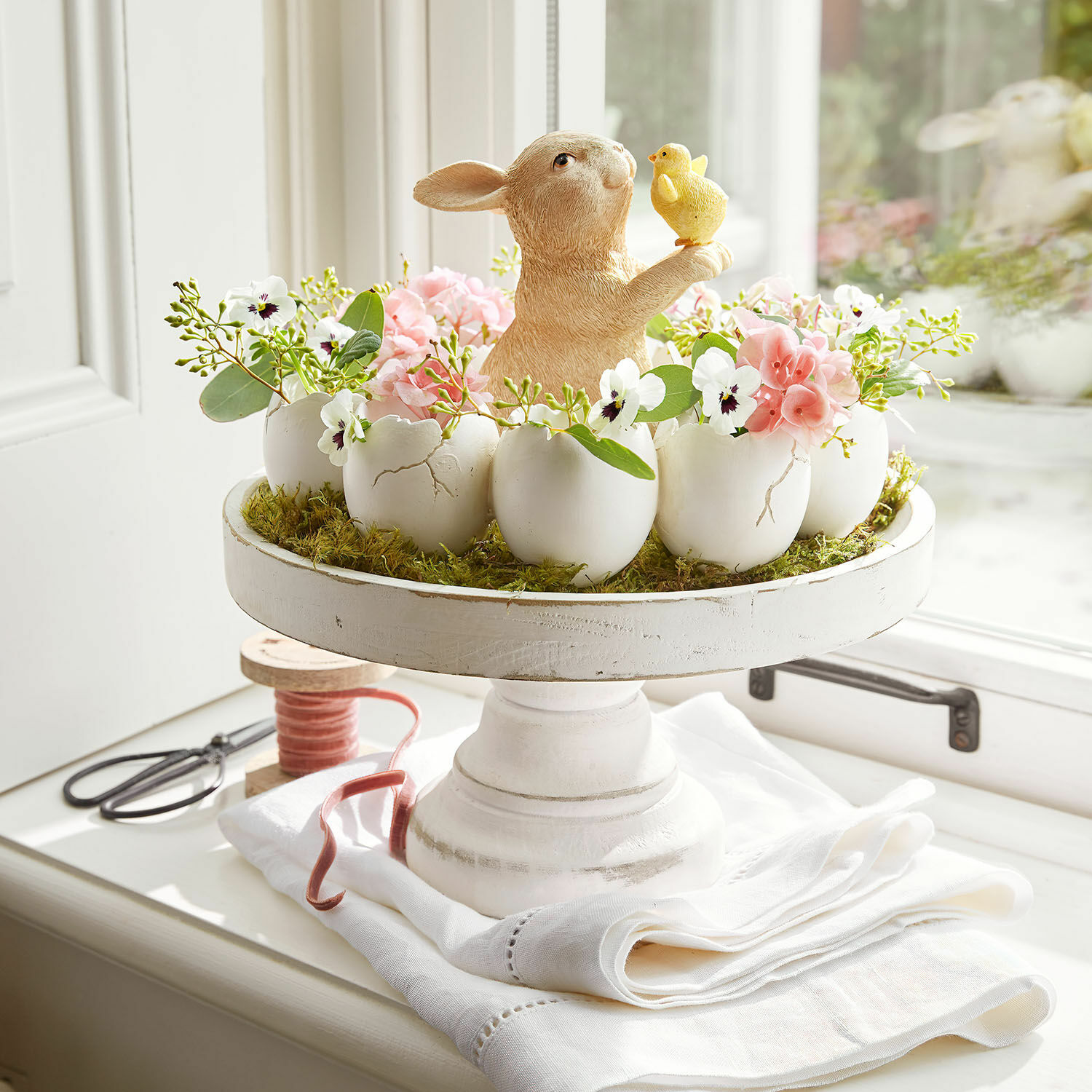Etagère Loissard Paasdecoratie met keramische haas en bloemen in witte eierschalen op een houten standaard