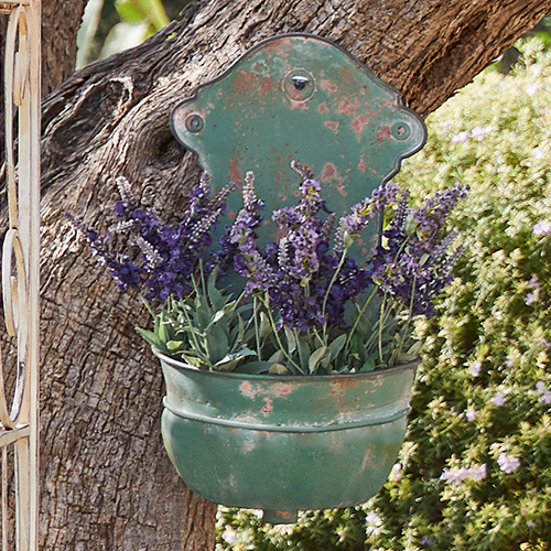 Groene metalen wandbloempot met verouderd effect en paarse lavendelbloemen voor tuin