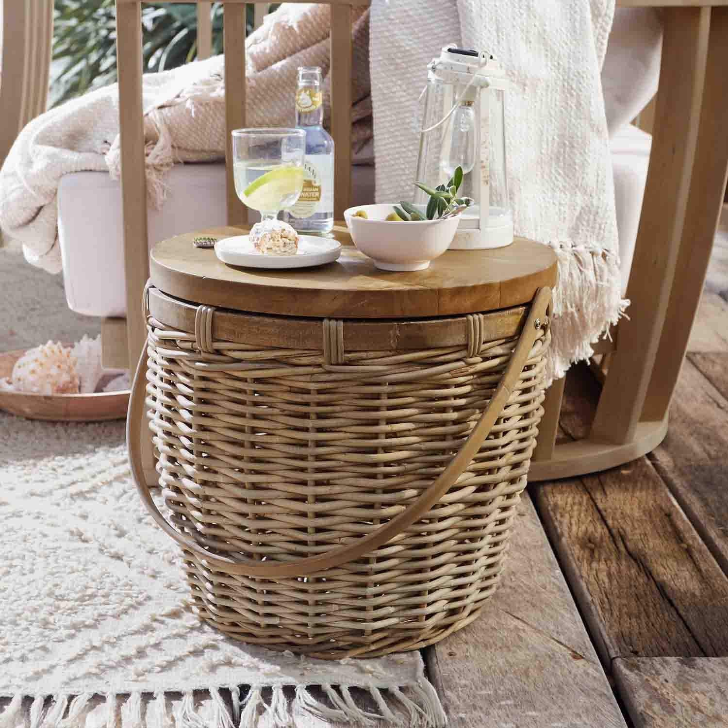 Ronde bijzettafel van natuurlijk riet en hout met lantaarn en snacks op houten terras