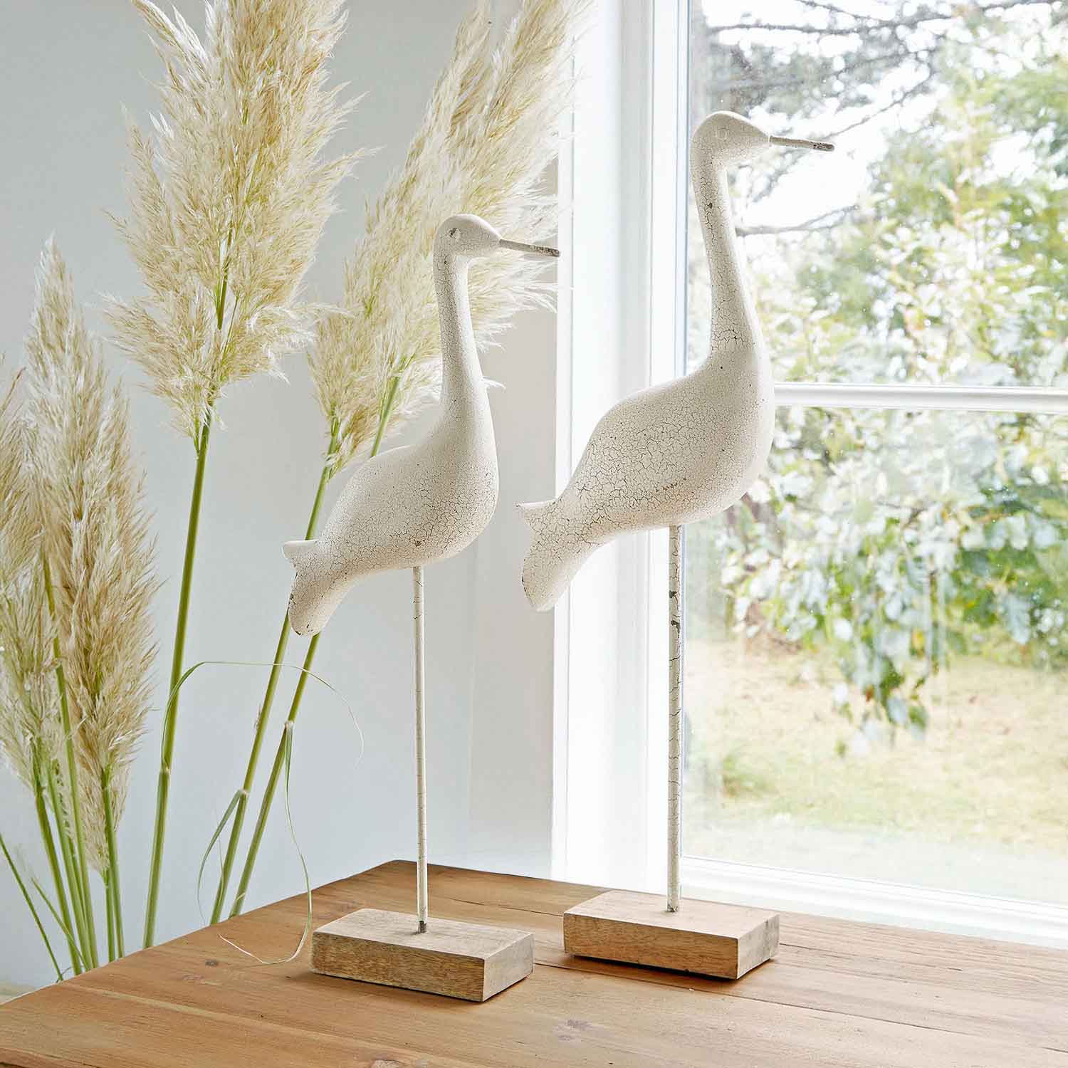 Witte decoratieve vogels van hout en metaal op houten voet, rustieke tafeldecoratie