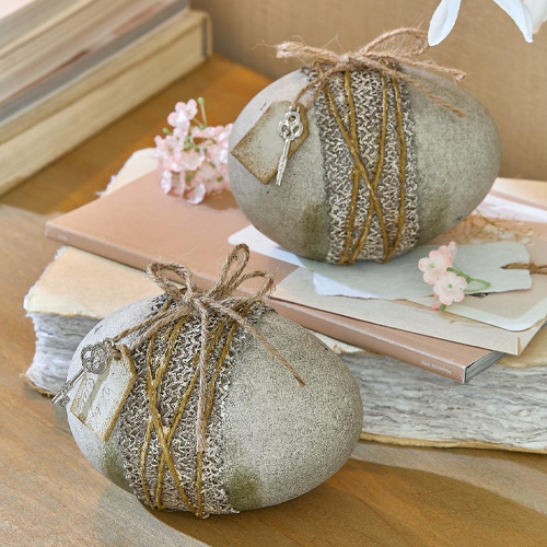 Pierres décoratives grises avec corde et clé en métal posées sur une table en bois avec livres