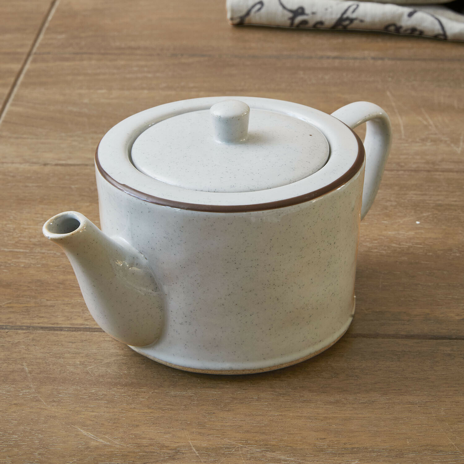 Theepot Biarré Witte keramische theepot met bruine rand op houten tafel voor het zetten van thee