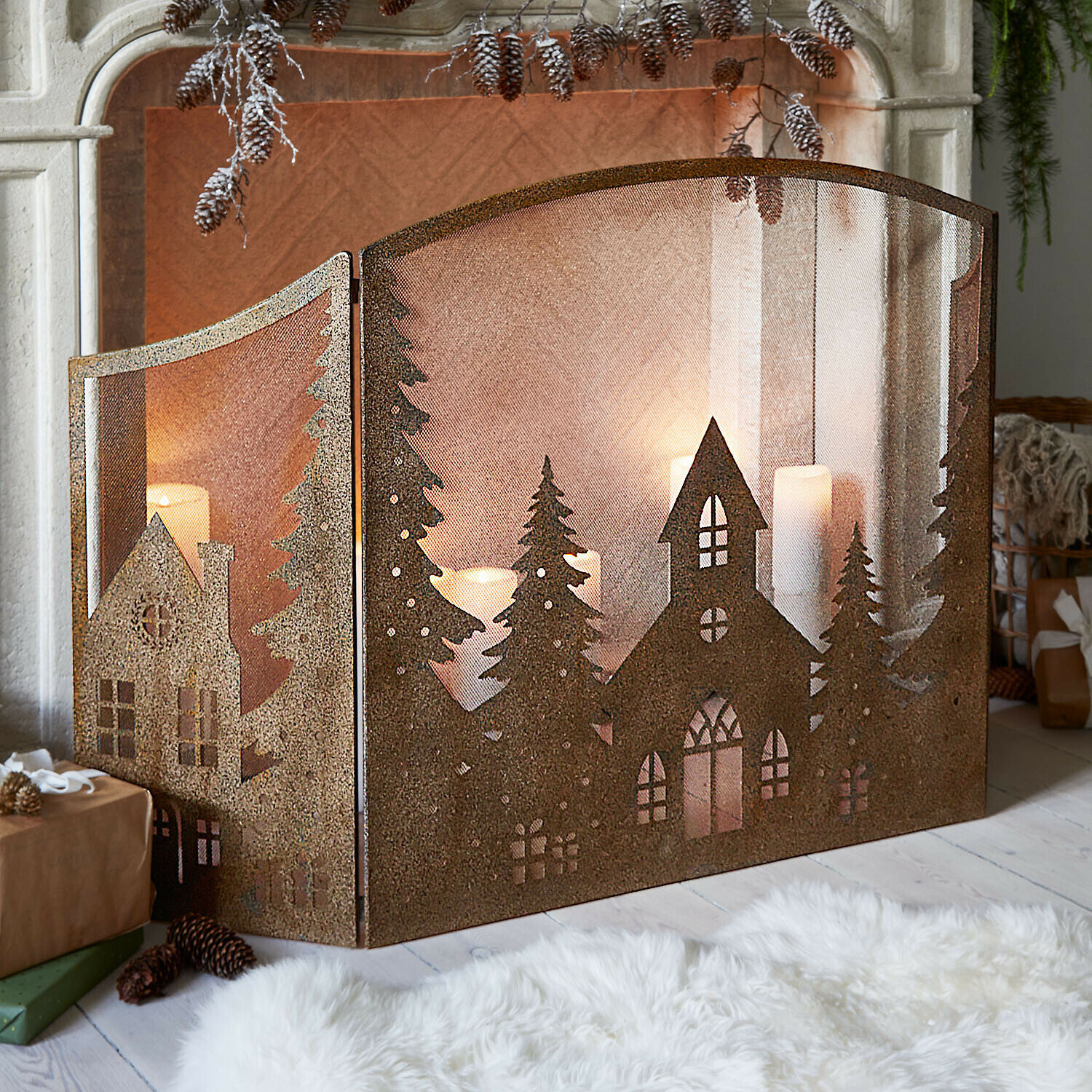Metalen haardscherm met huis- en boommotief in roestkleur, sfeervolle kerstdecoratie voor woonkamer