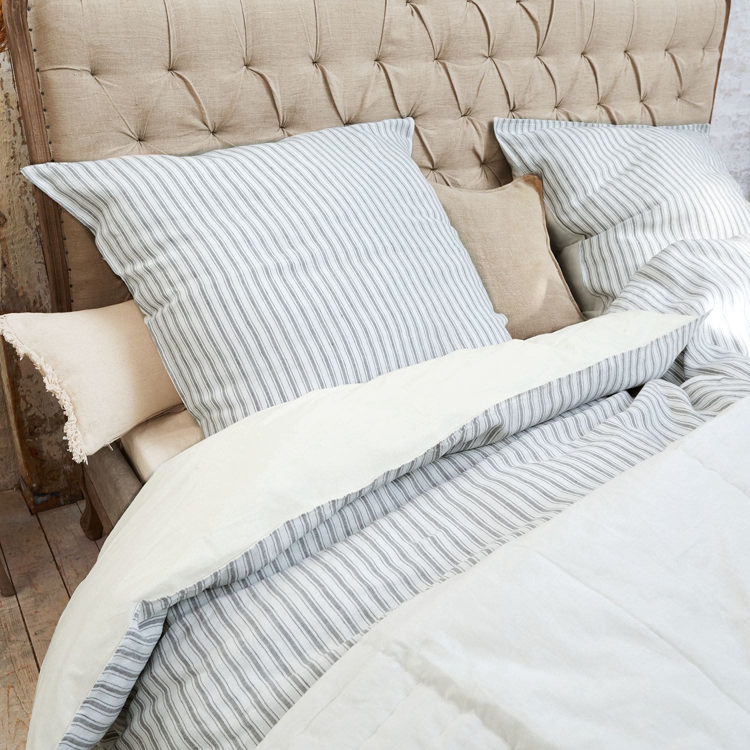 Parure de lit Stripes Parure de lit rayée en coton gris et blanc sur tête de lit capitonnée beige en tissu