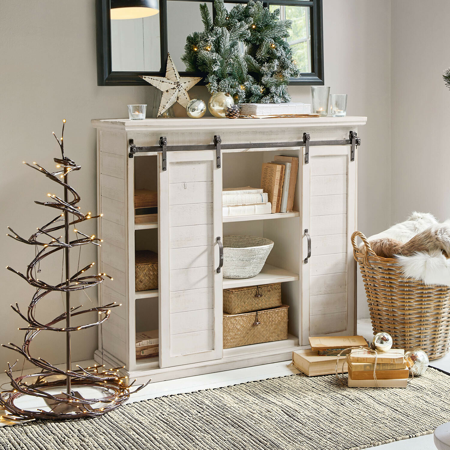 Commode Perrin Buffet en bois blanc avec portes coulissantes et décorations de Noël dans un salon lumineux