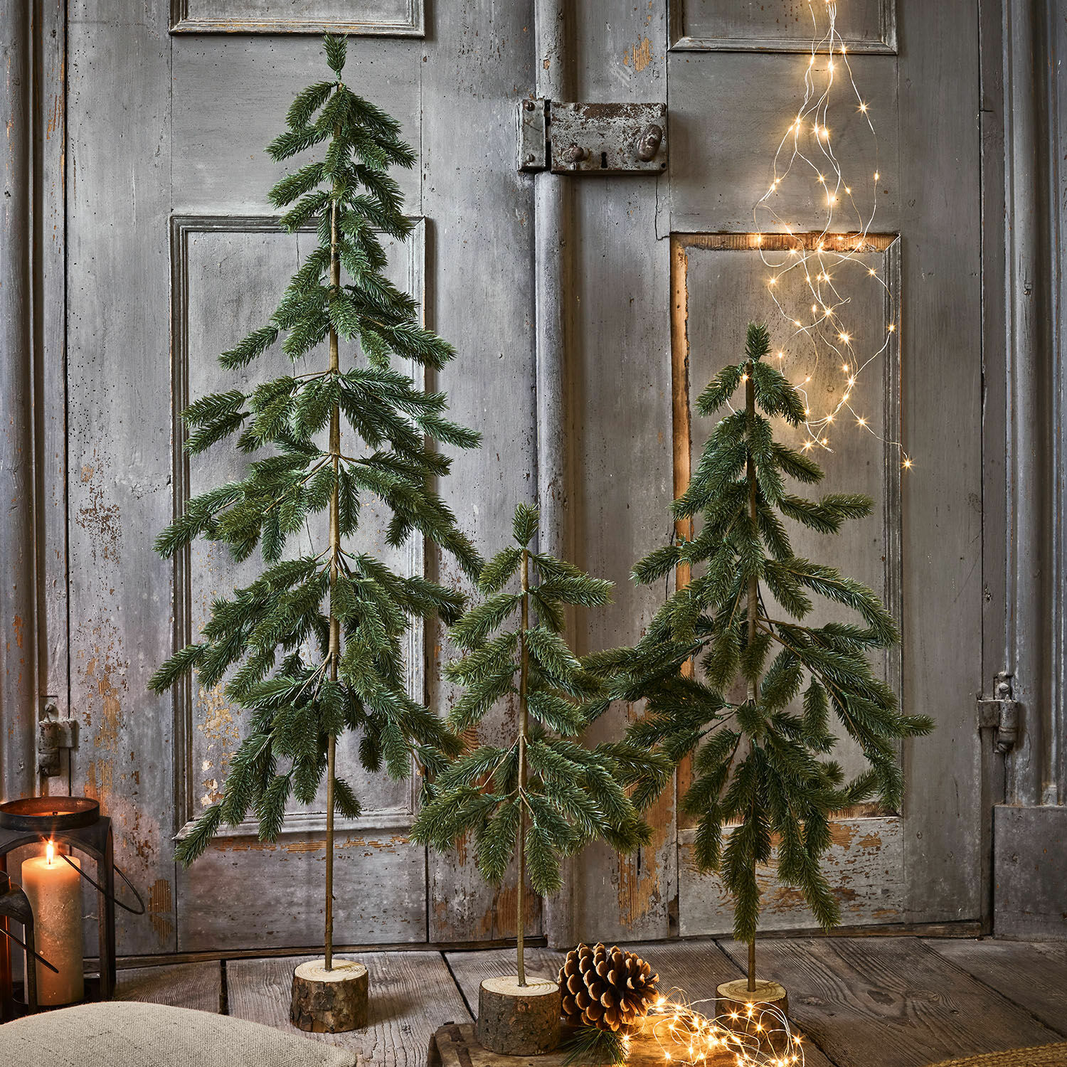 Kerstboom set van 3 Lorin Drie decoratieve groene kerstbomen op houten voet met LED-lichtjes en dennenappel als decoratie