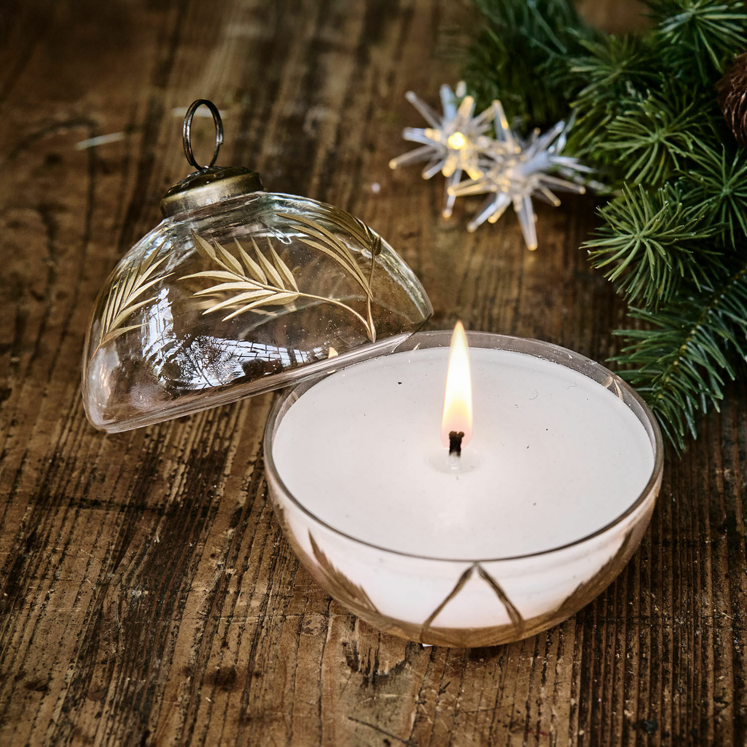 Photophore avec bougie Belathor Bougie parfumée dans un récipient en verre transparent avec motif doré de feuilles sur une table en bois