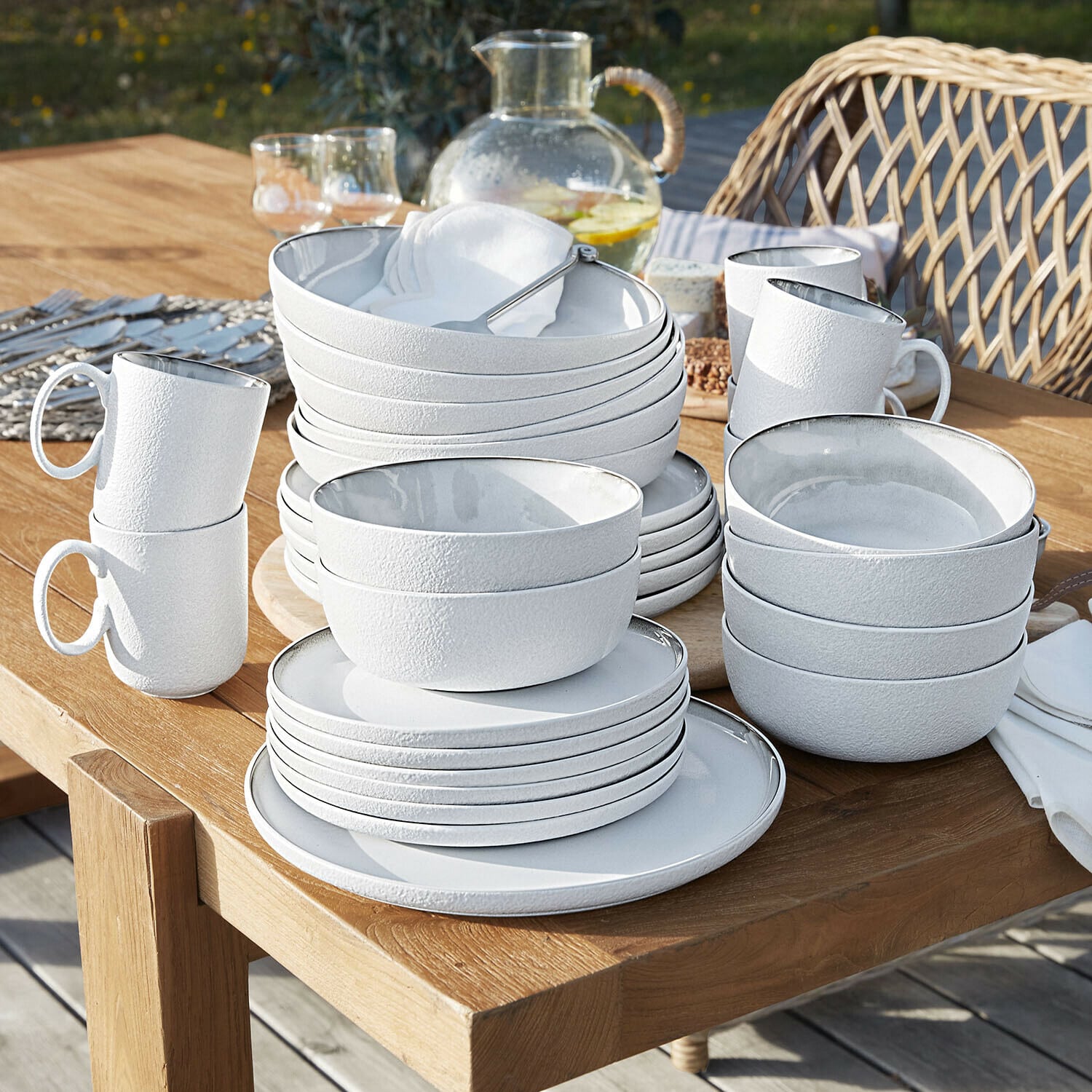 Servies set van 30 Eiruna Witte keramische servies set met textuur gestapeld op houten tafel buiten