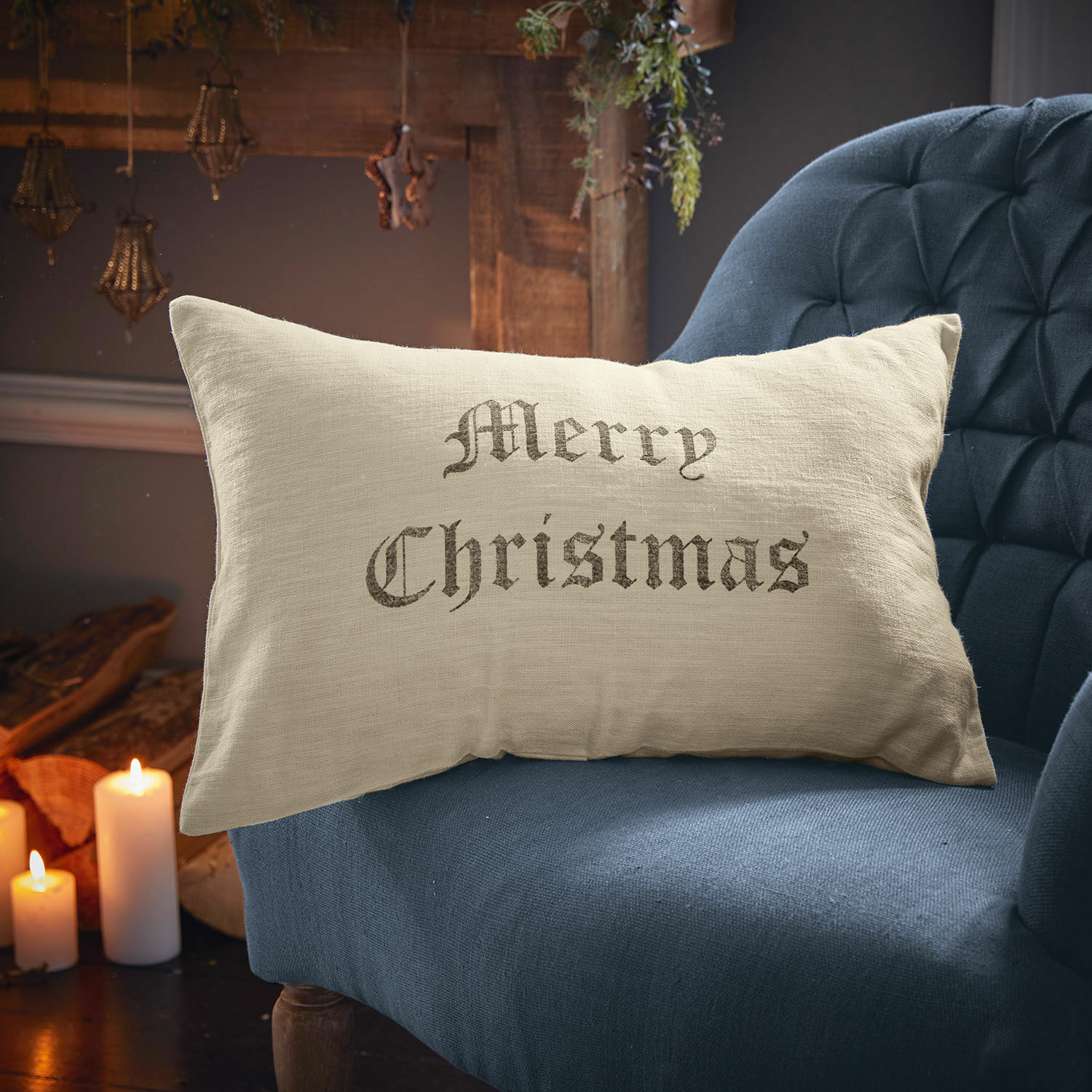 Kussenhoes Merry Christmas Beige linnen kussen met tekst Merry Christmas op blauwe stoel, kerstdecoratie
