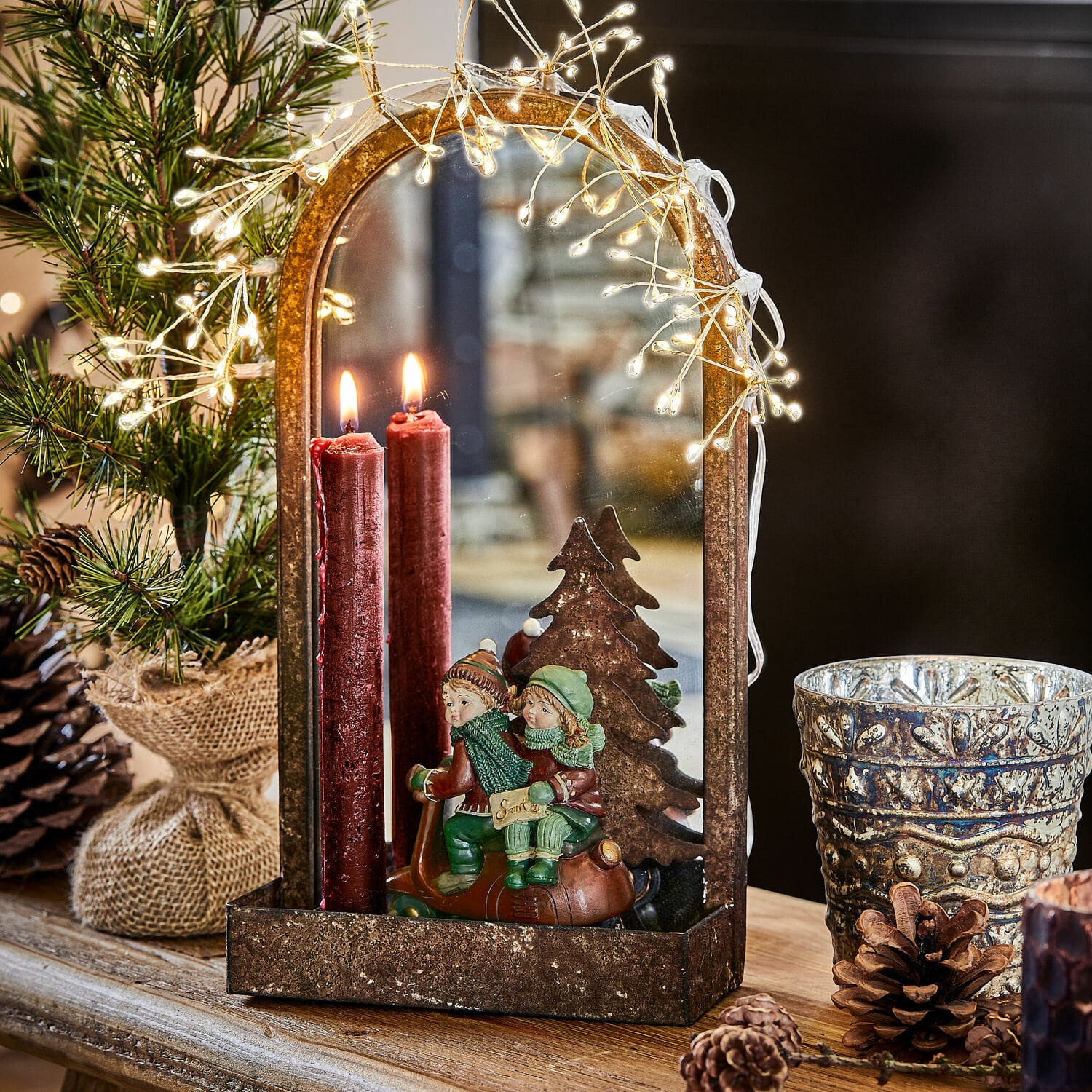 Wandkaarsenhouder Telford Decoratieve metalen lantaarn met spiegel, rode kaarsen en kinderfiguren op scooter als kerstdecoratie