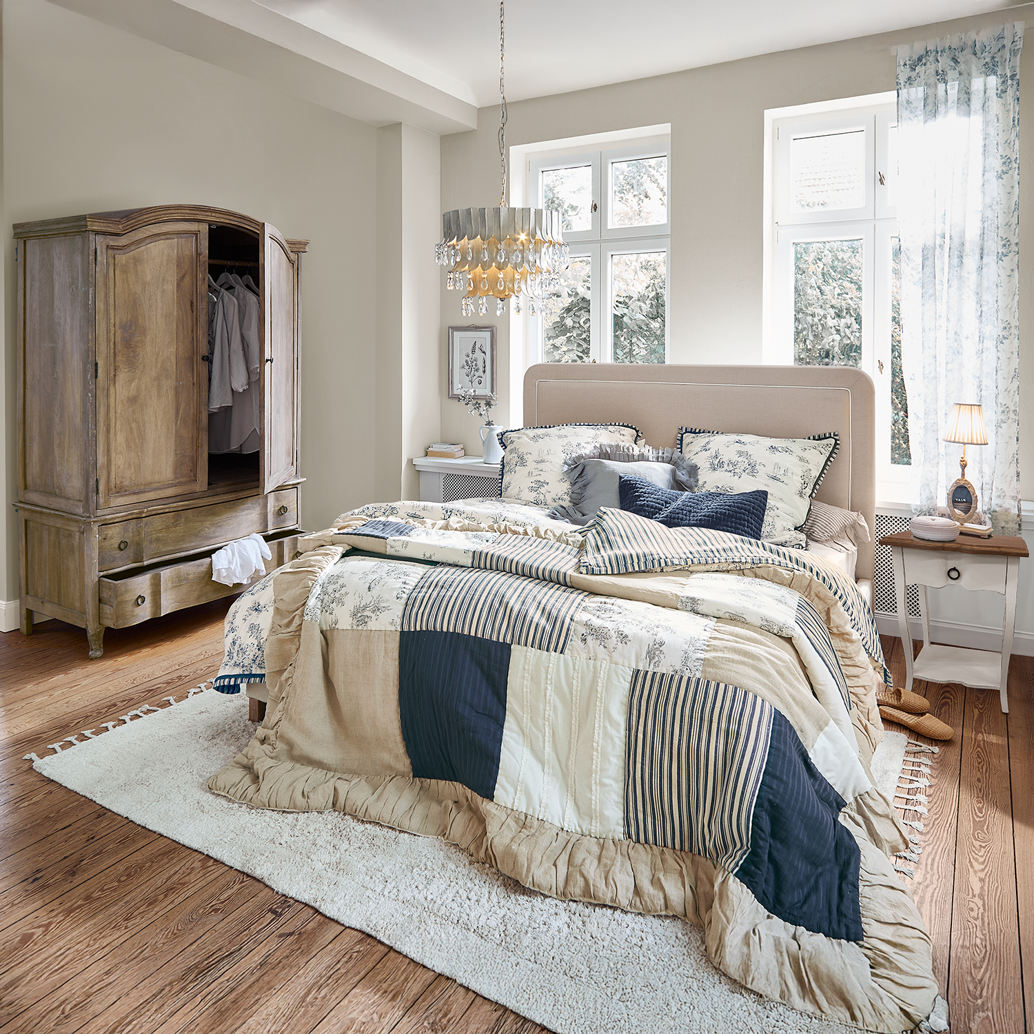 Gezellige slaapkamer met patchwork dekbed in beige en donkerblauw, houten kast en zacht vloerkleed