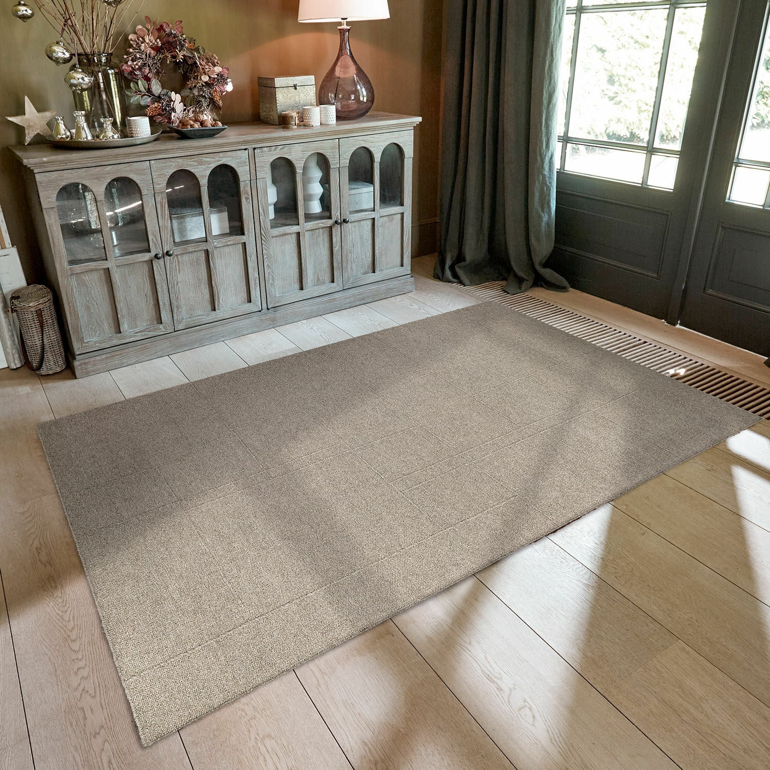 Vloerkleed Tharim Beige vloerkleed met subtiel patroon op lichte houten vloer in moderne kamer