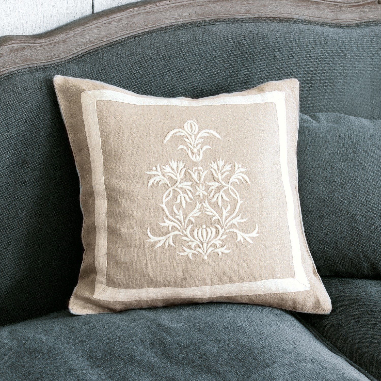 Kussenhoes Many Beige linnen kussen met witte borduursel op grijze bank, decoratief woonaccessoire