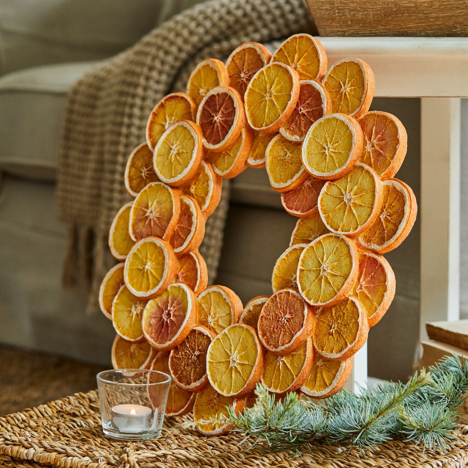 Couronne décorative en tranches d'orange séchées aux tons chauds posée sur un fond naturel