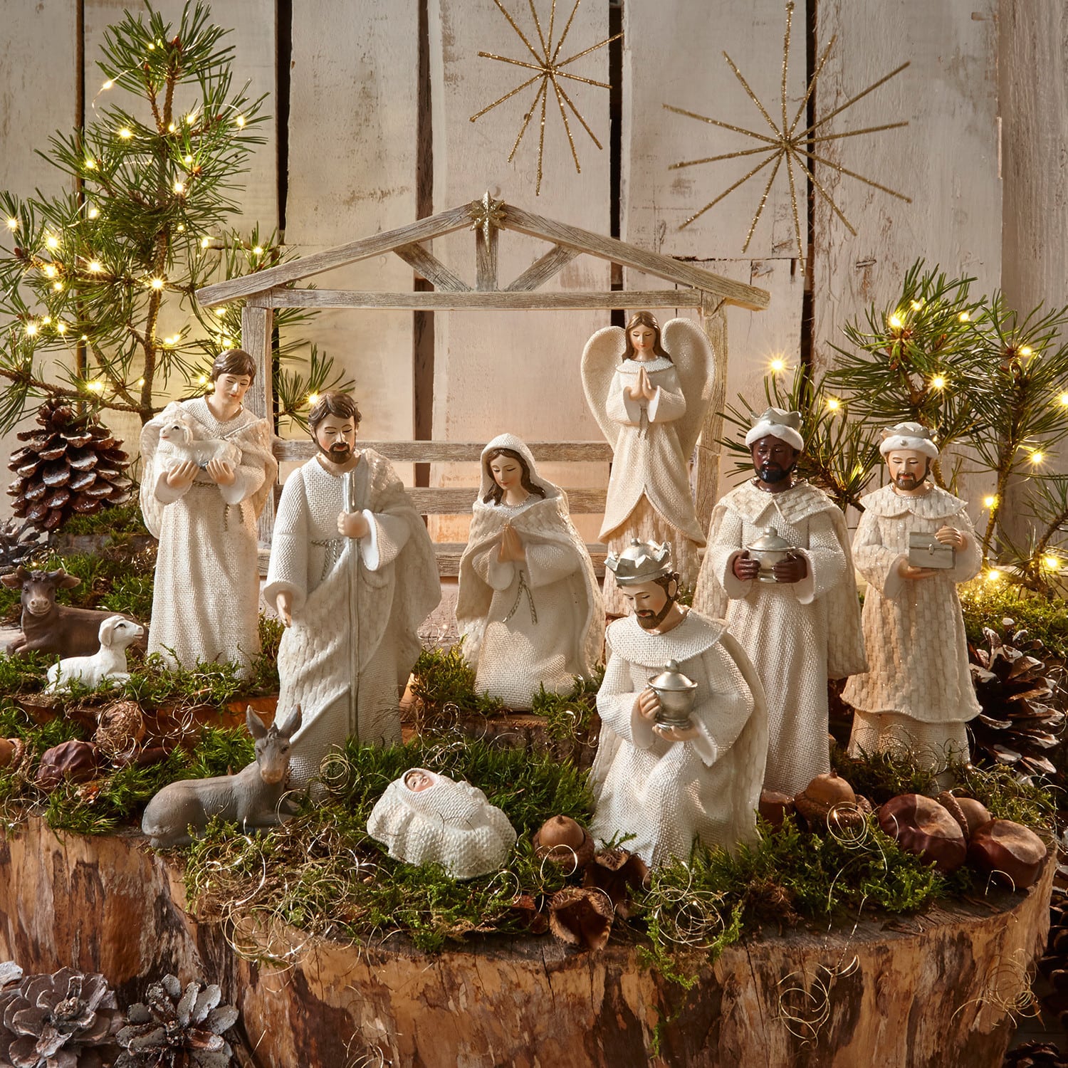 Kerststalfiguur set van 12 Santo Set witte kerststalfiguren van hout en stof op natuurlijke achtergrond met mos en lichtjes voor kerstdecoratie