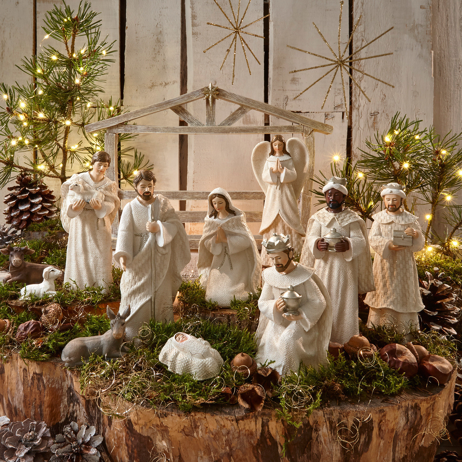 Kerststalfiguur set van 12 Santo Set witte kerststalfiguren van hout en stof op natuurlijke achtergrond met mos en lichtjes voor kerstdecoratie