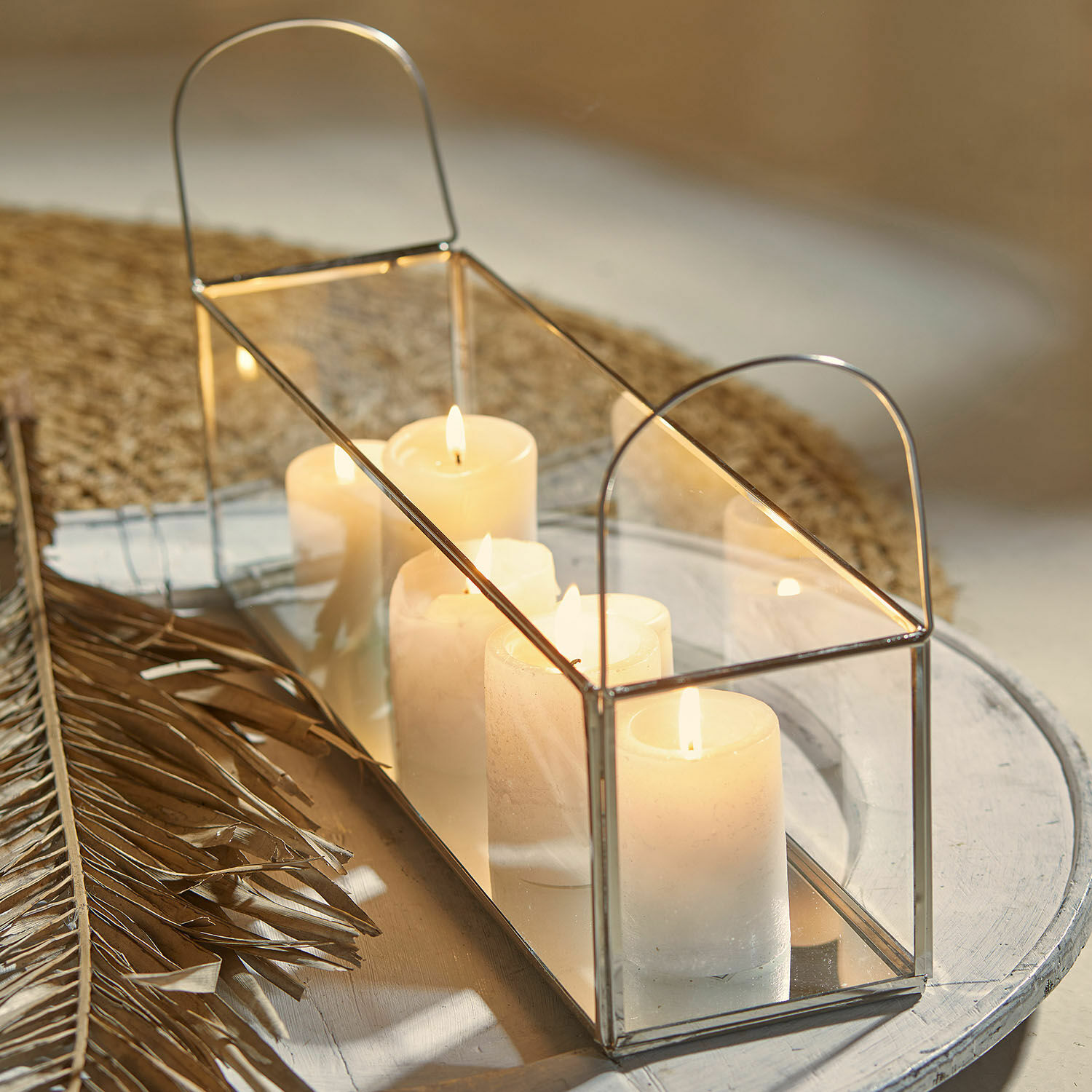 Lanterne rectangulaire en métal avec miroir et bougies blanches sur table décorative