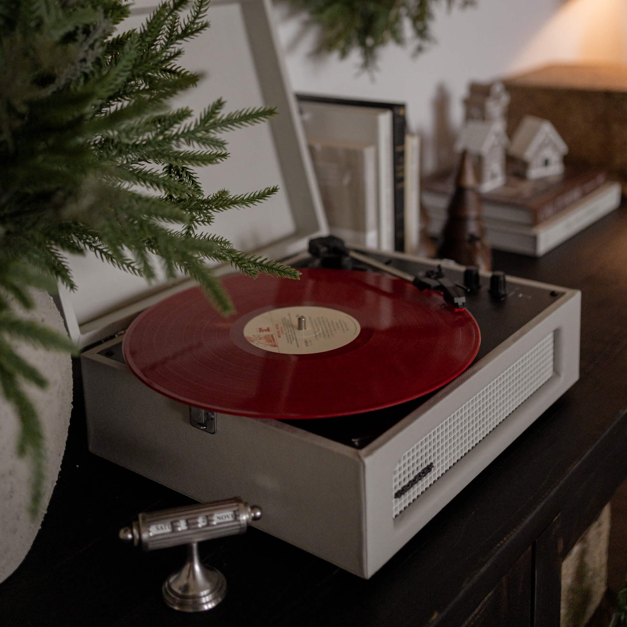 Retro platenspeler met rode vinylplaat op donkere kast in sfeervolle kamer