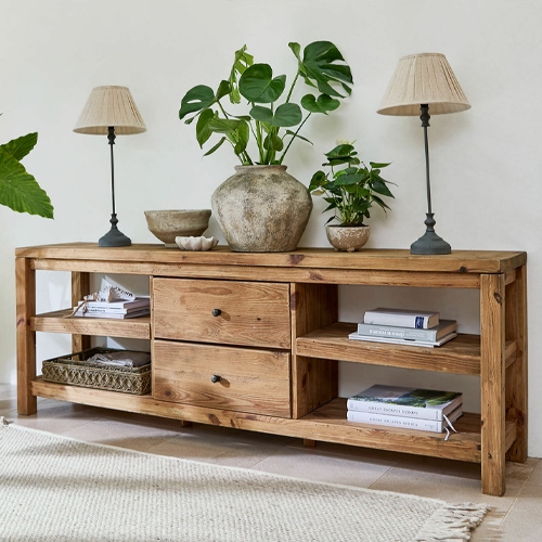 Console en bois avec tiroirs et étagères, décorée de lampes et plantes, style naturel