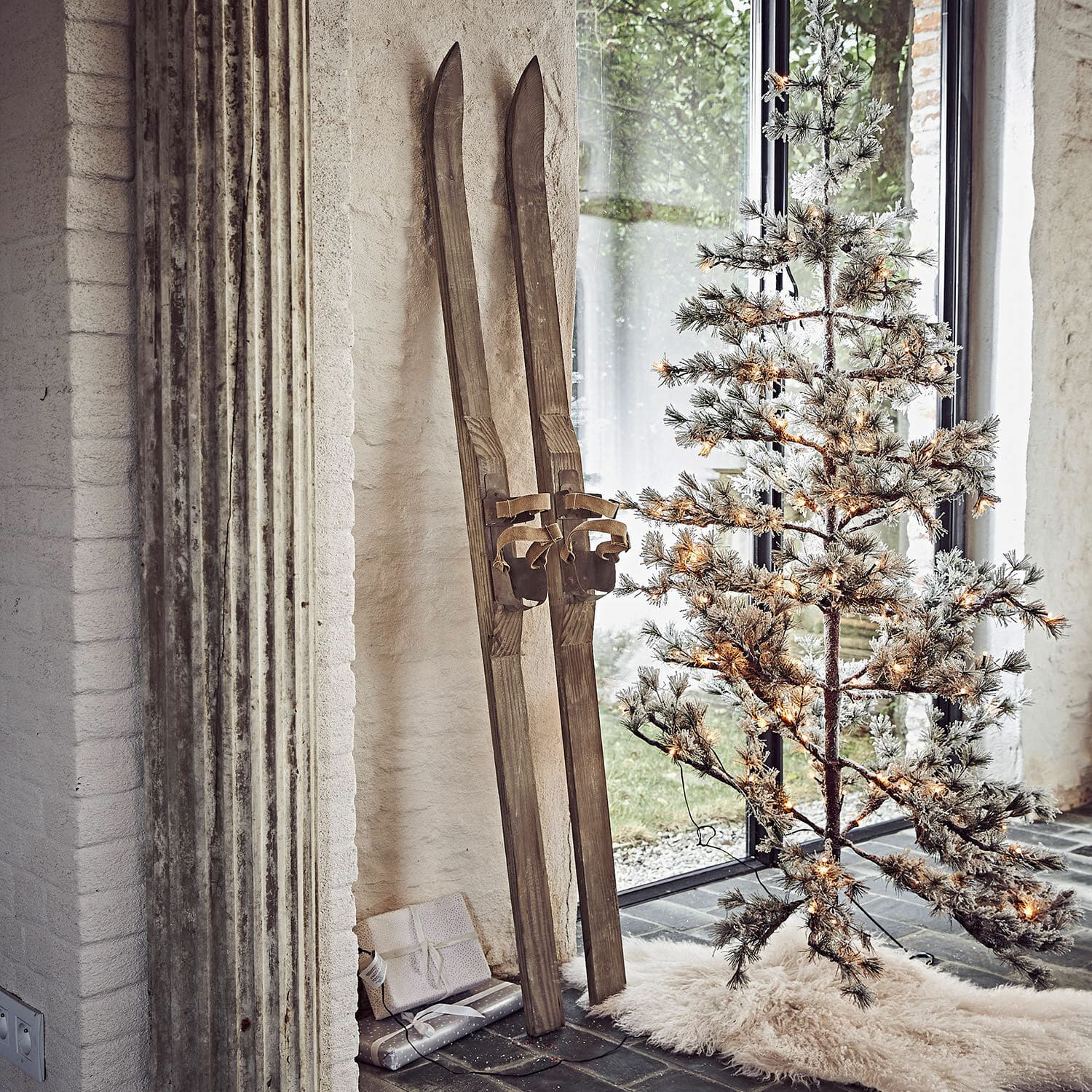 Lot de 2 skis décoratifs Lambeth Paires de skis en bois vintage près d'un sapin artificiel éclairé avec tapis blanc au sol