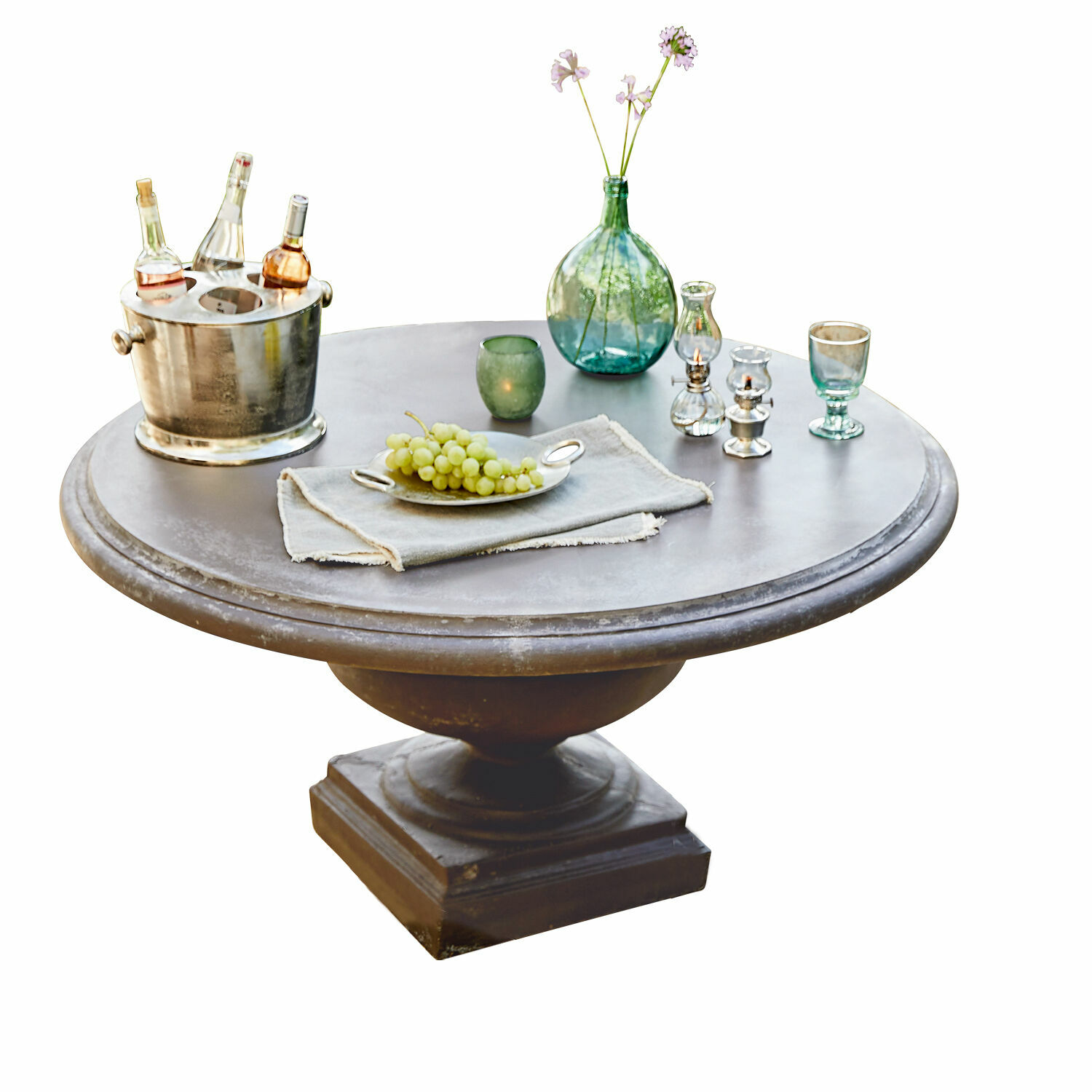 Table ronde grise Monterey avec décorations et bouteilles sur fond blanc, meuble de salon