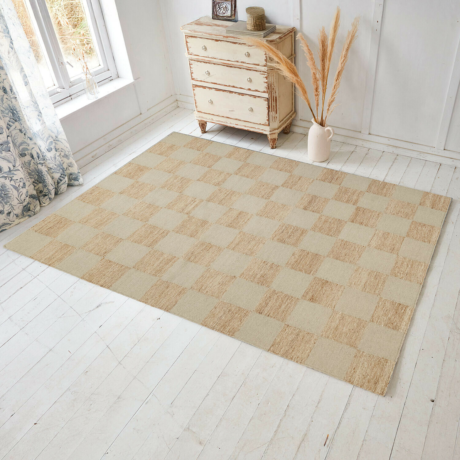 Vloerkleed Nexari Beige geruite vloerkleed van natuurlijk materiaal op lichte houten vloer in lichte kamer
