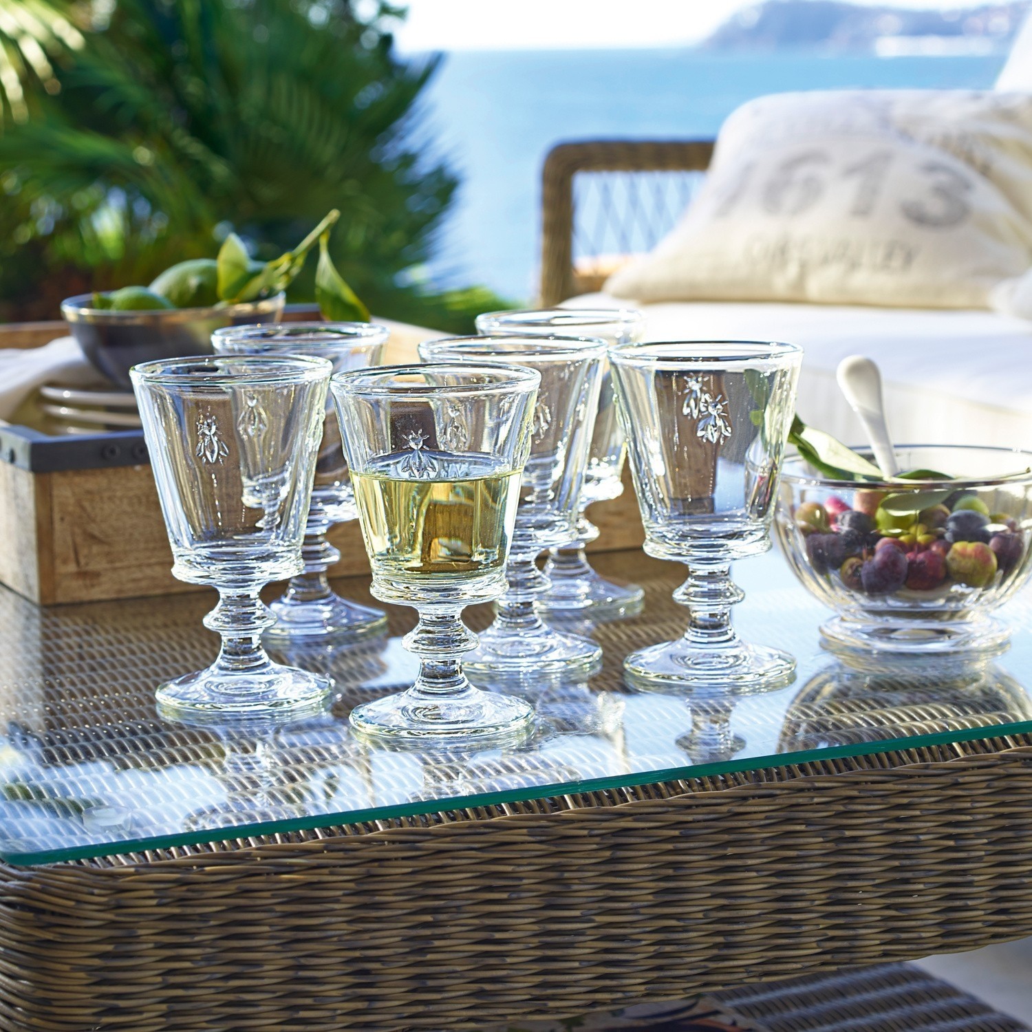 Wijnglas set van 6 Puttigny Set van zes glazen met insectmotief op glazen tafel op terras met uitzicht op zee