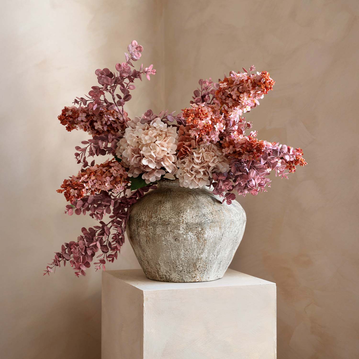 Rustieke stenen vaas met boeket roze en beige decoratieve bloemen voor interieurdecoratie