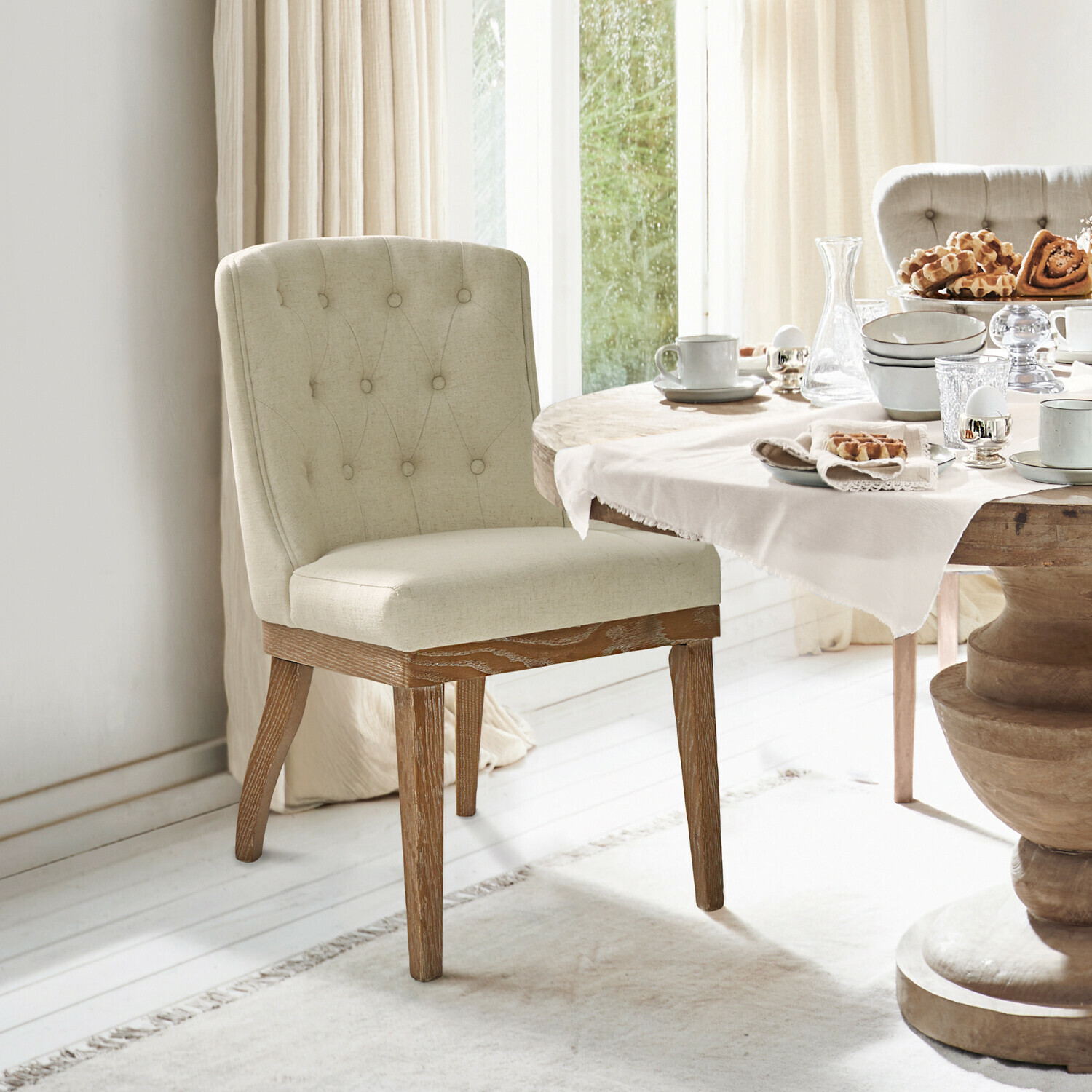 Stoel Fairwyn Beige gestoffeerde stoel met houten poten bij eettafel met servies en gebak