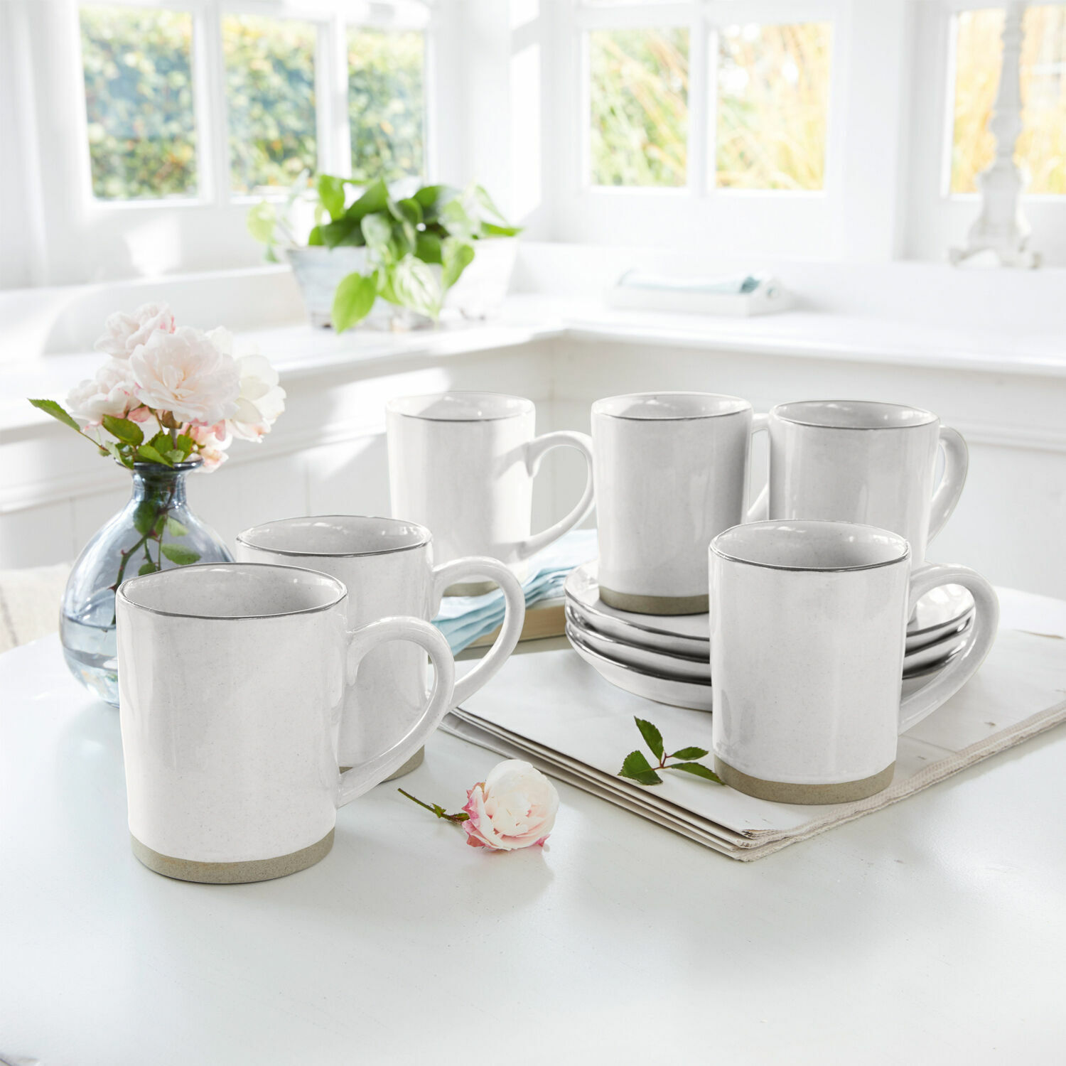 Lot de 6 tasses Biarré Ensemble de six mugs en céramique blanche avec bord gris sur une table claire dans un intérieur lumineux