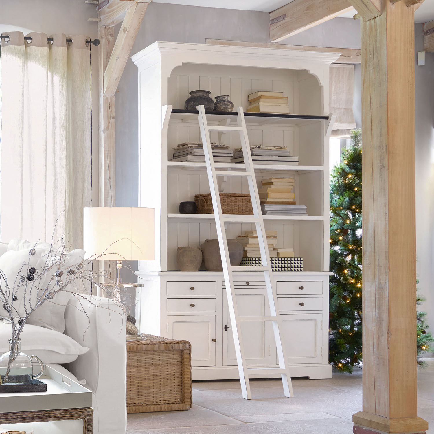 Kast Monts Witte houten boekenkast met ladder en decoraties in lichte woonkamer met natuurlijk licht