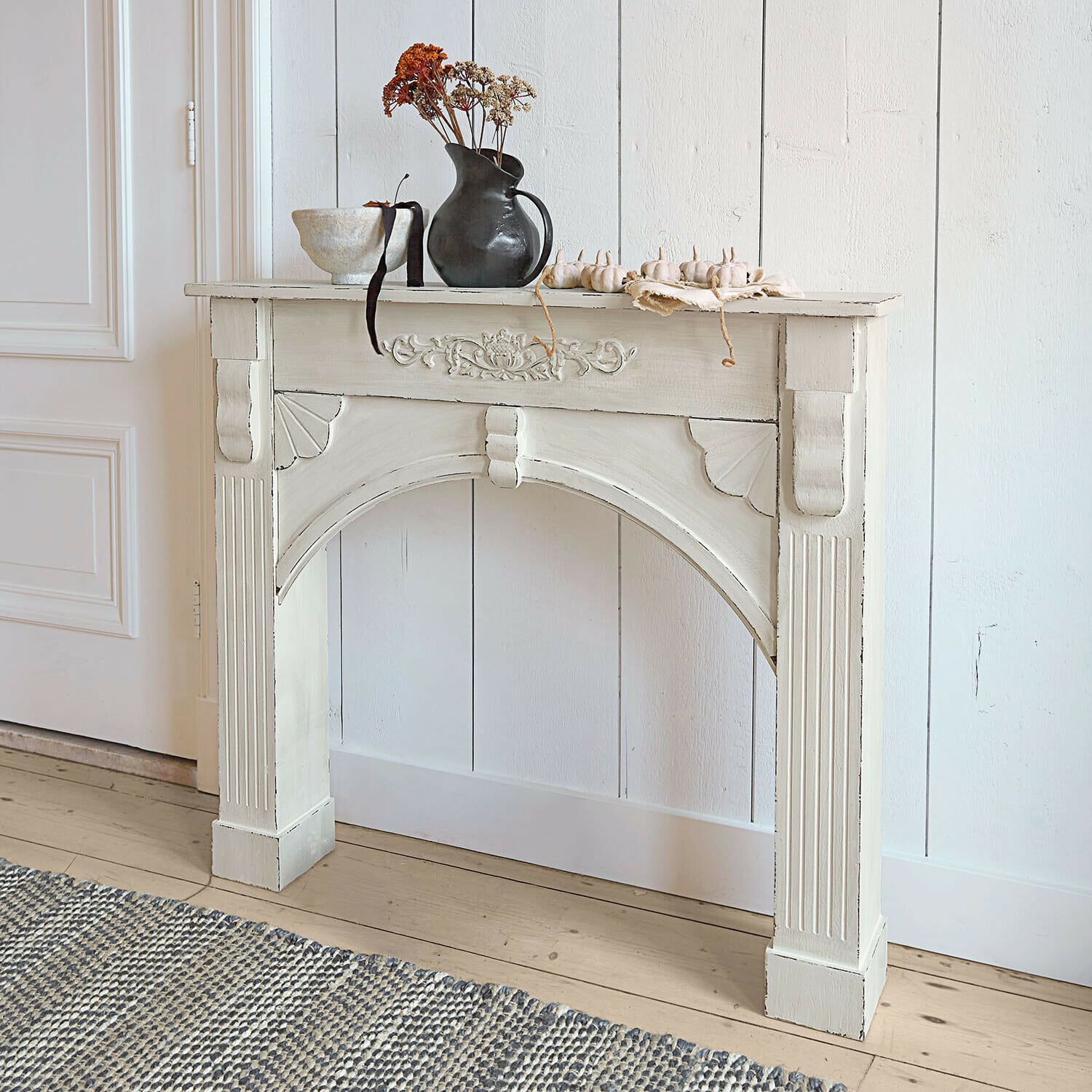 Haardschouw Maxwell Witte houten sidetable met decoratieve houtsnijwerk en vaas met gedroogde bloemen erop