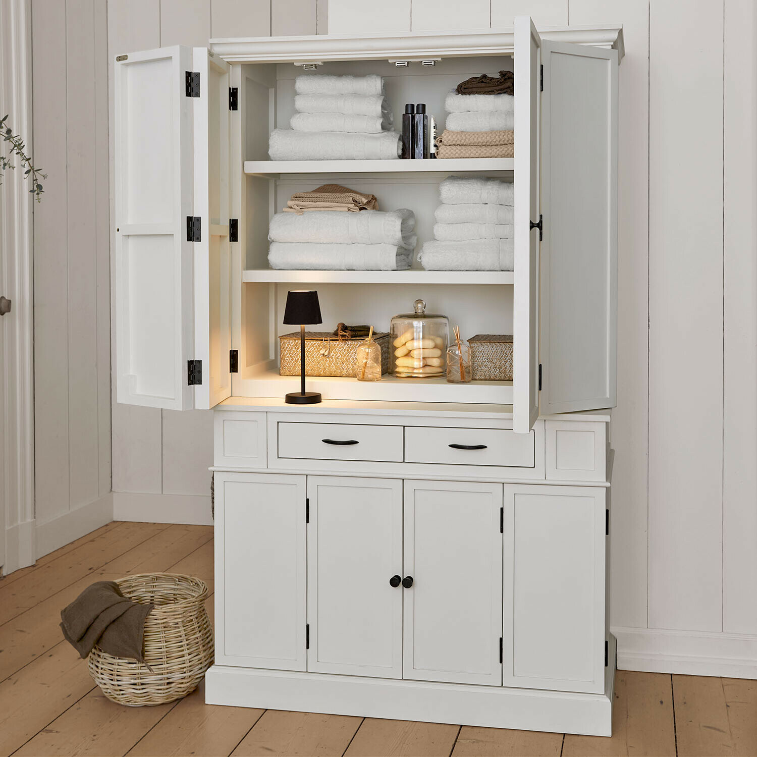 Armoire Lydia Armoire en bois blanc ouverte avec serviettes blanches et décorations, meuble de salle de bain élégant