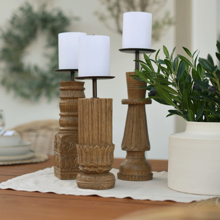Drie houten kandelaars met witte kaarsen op een tafel, natuurlijke interieurdecoratie