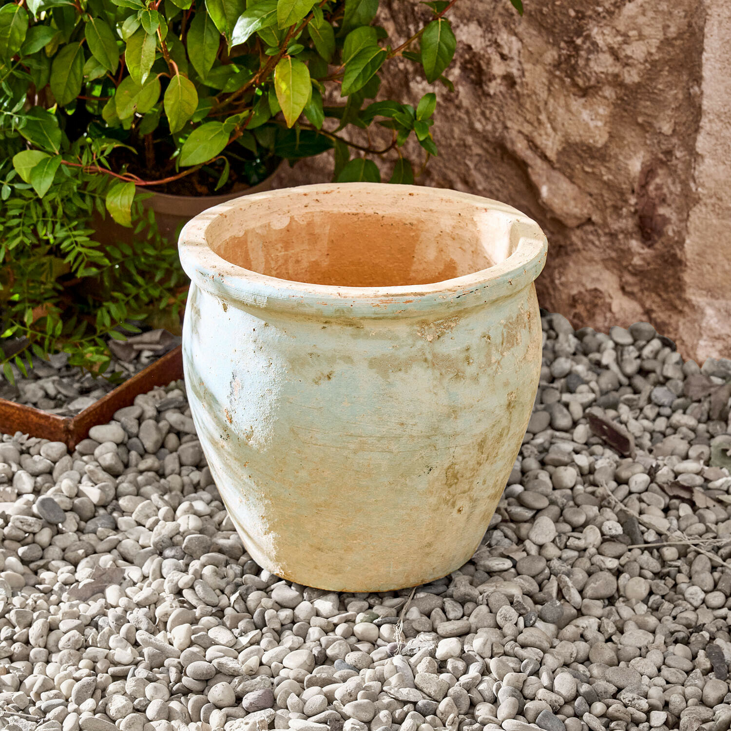 Sierpot Naldorín Grote lichtbeige keramische bloempot op kiezelstenen in een tuin