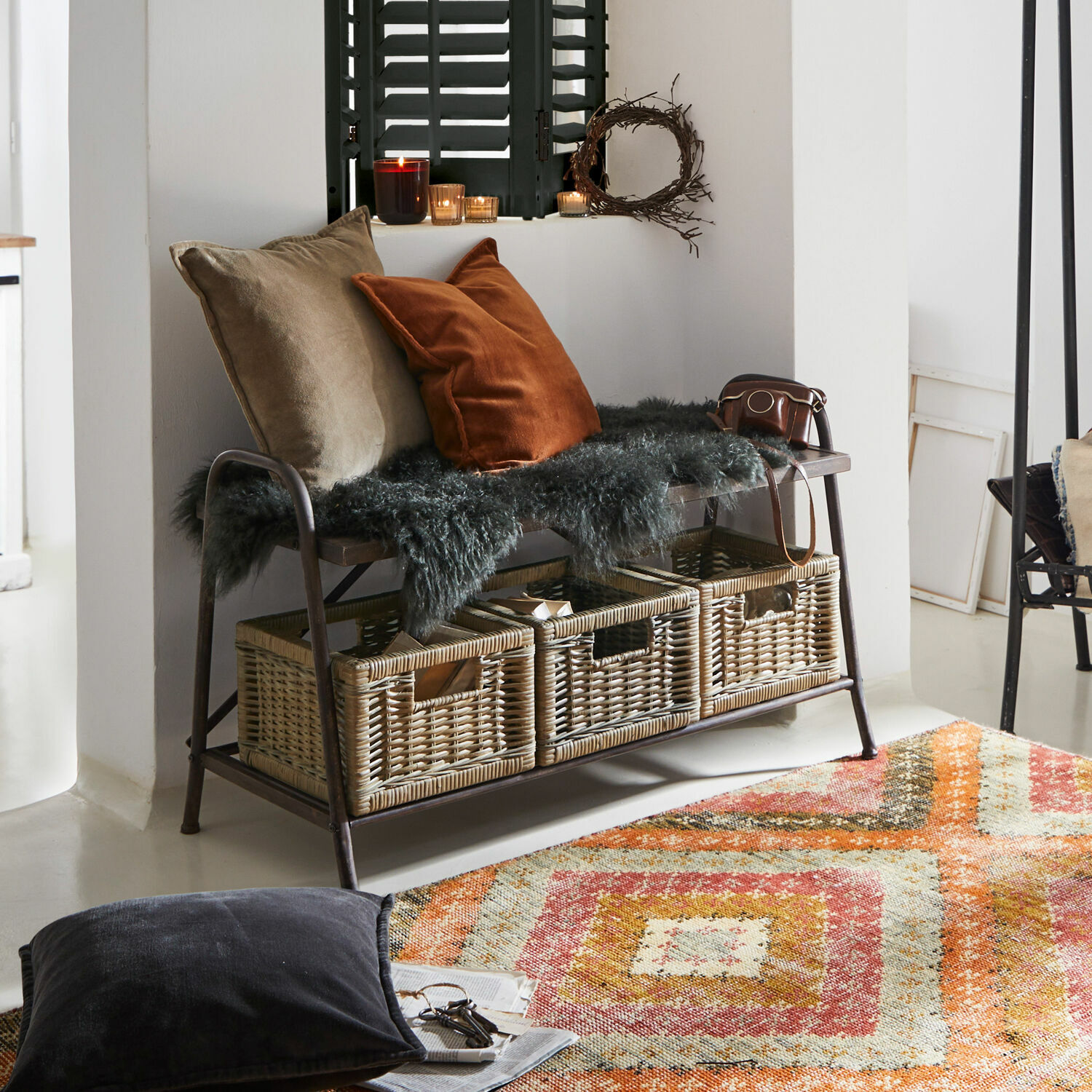 Banc Lapalisse Banc avec cadre en métal et trois paniers en osier, coussins et couverture en fourrure dans un salon