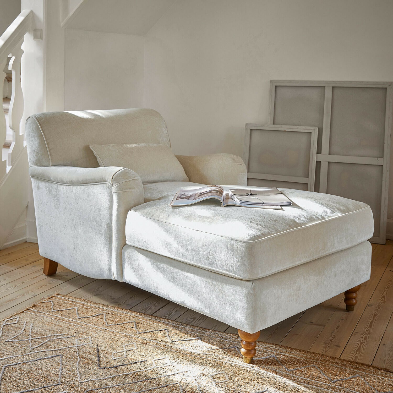 Chaise longue Isa Beige fauteuil van zachte stof met voetensteun en houten poten in lichte woonkamer