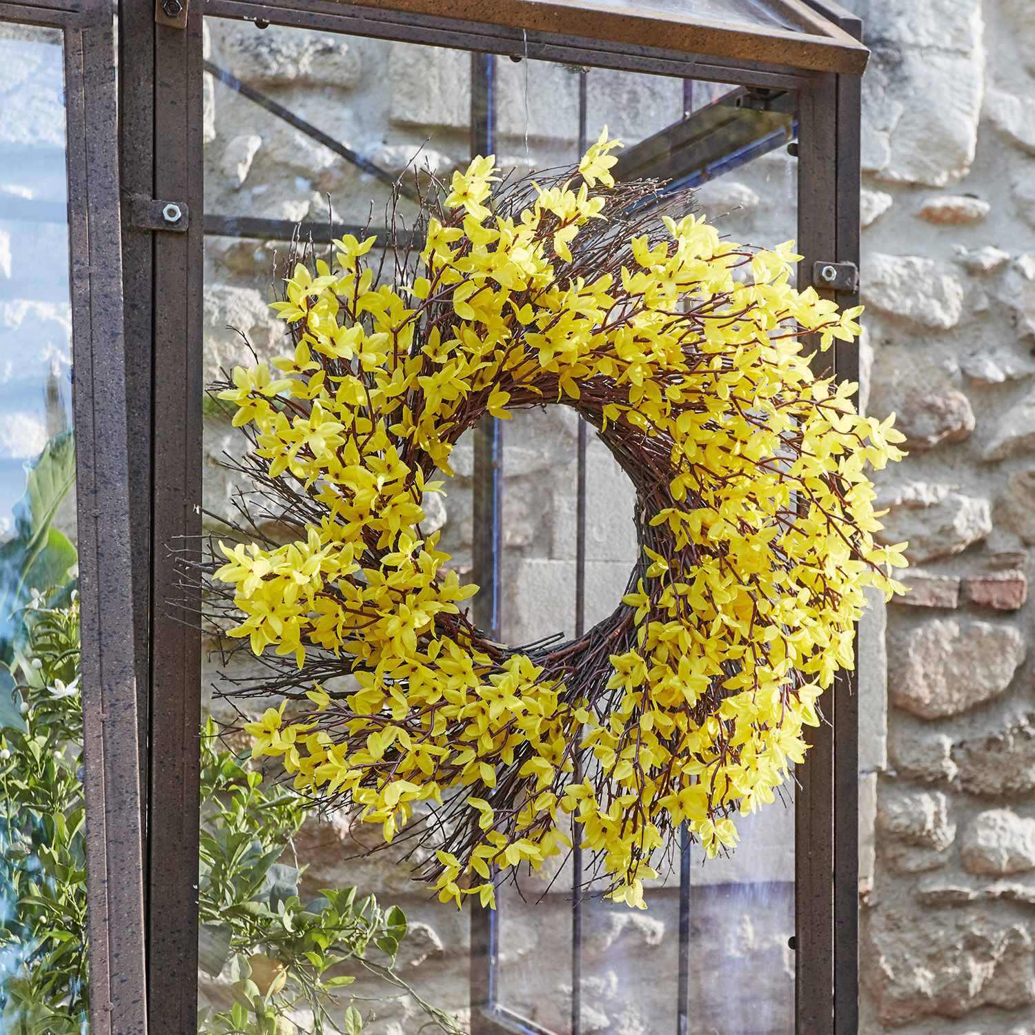 Couronne décorative avec fleurs jaunes et branches sur cadre métallique, décoration printanière intérieure et extérieure