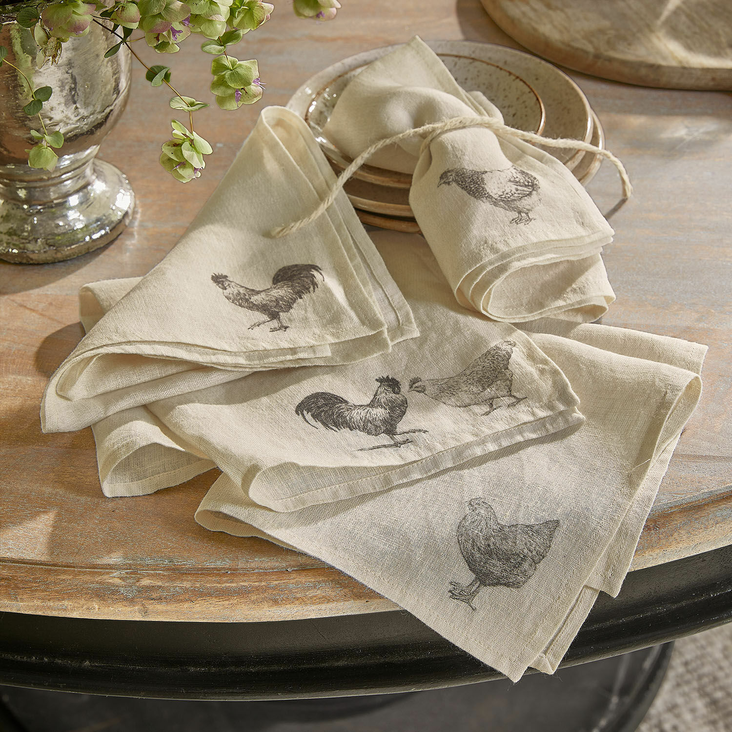 Servet set van 4 Walorine Beige linnen servetten met opdruk van kippen en hanen op rustieke houten tafel