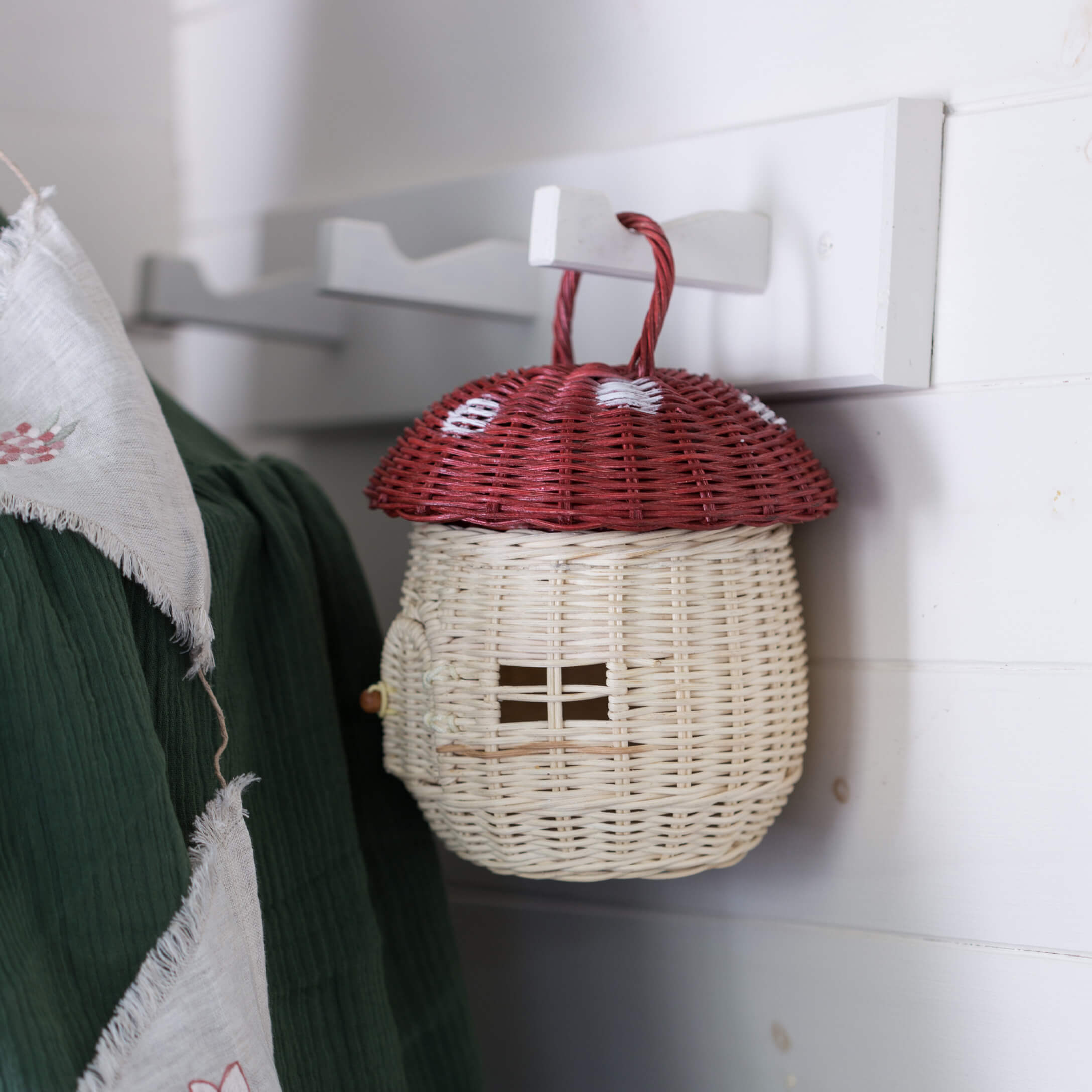 Panier décoratif en osier en forme de champignon rouge avec chapeau rouge et corps blanc suspendu à un crochet