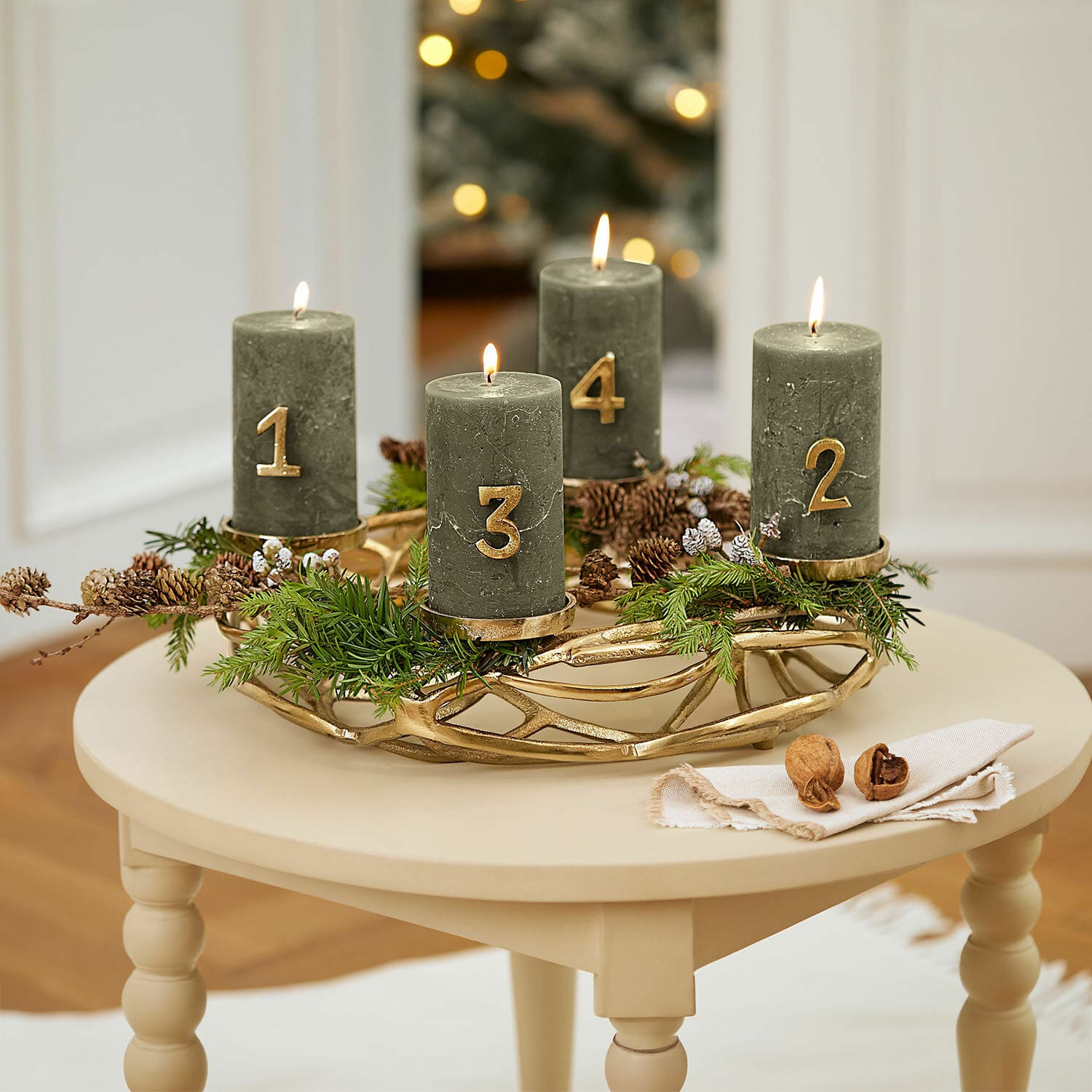 Kaarsenkrans Coldfield Groene adventskrans met vier kaarsen en gouden cijfers op een beige tafel