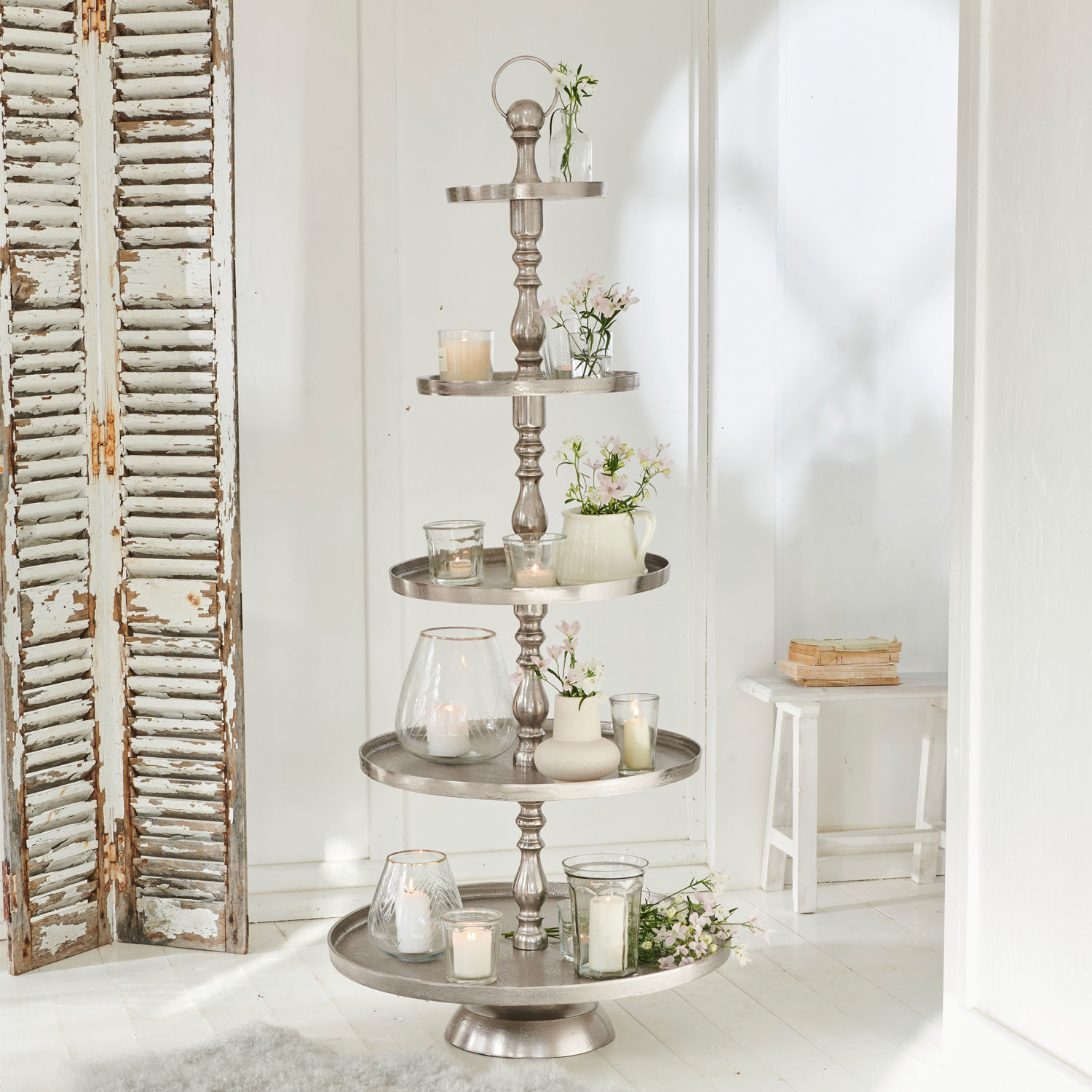 Présentoir à étages Magonie Présentoir décoratif à cinq niveaux en métal argenté avec bougies et fleurs blanches
