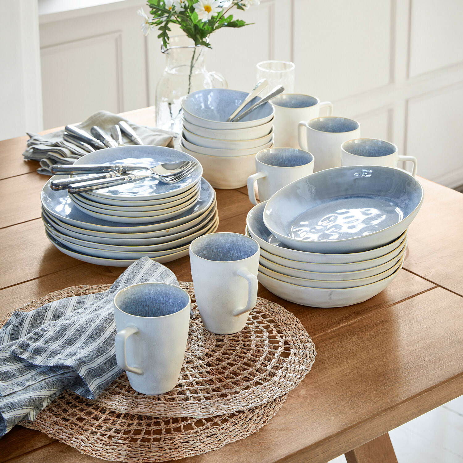 Servies set van 30 Vionette Blauw-wit keramisch servies op houten tafel met gestreepte stoffen servetten