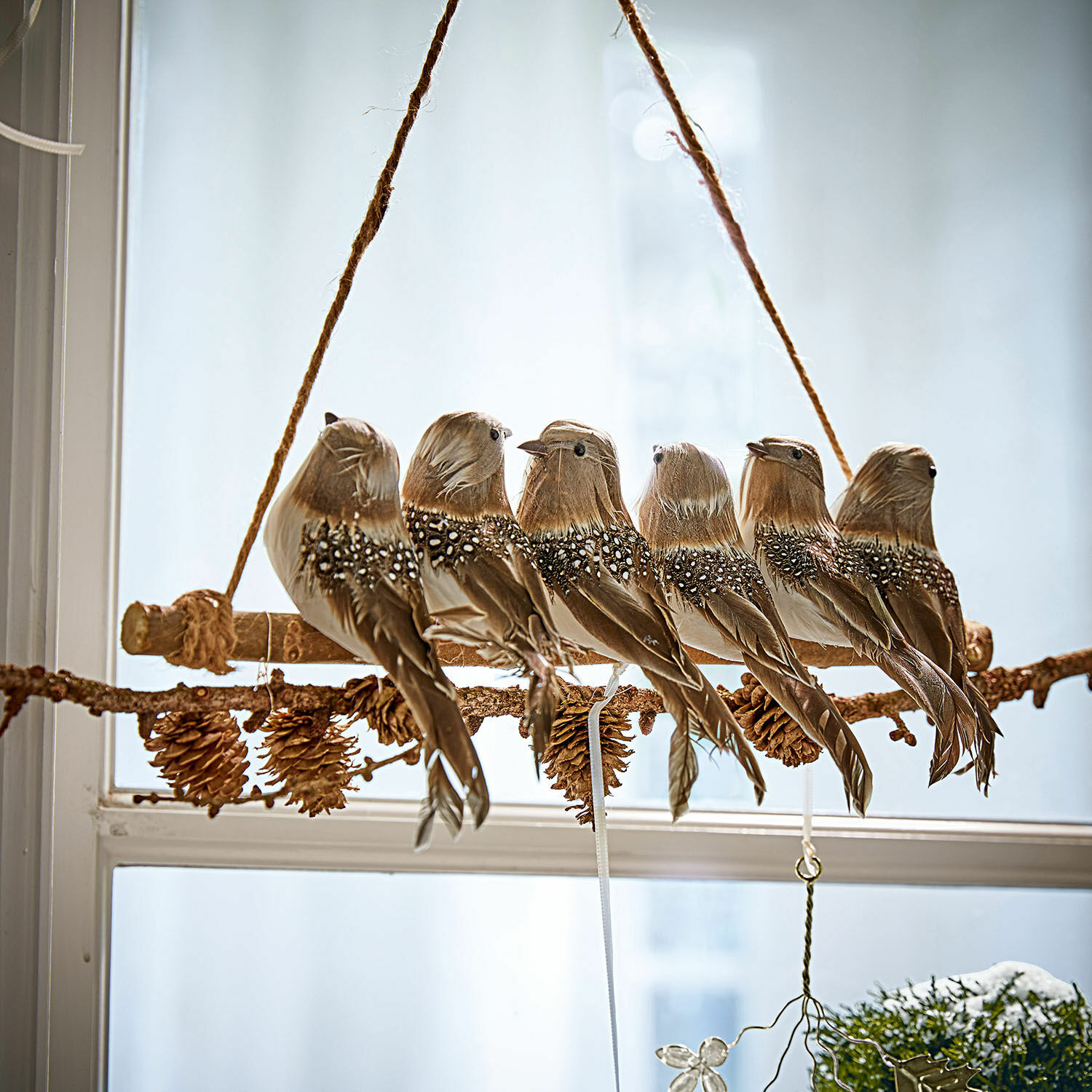 Oiseaux perchés Orely Décoration suspendue avec six oiseaux bruns en plumes sur une branche avec pommes de pin, ornement de fenêtre