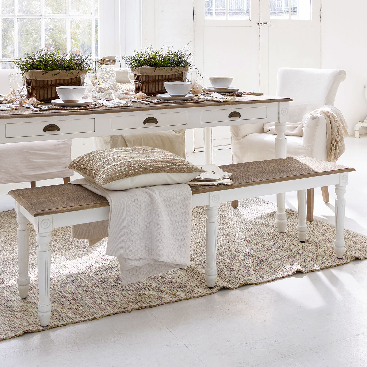 Banc Helsinquia Banc en bois blanc avec plateau marron dans un salon lumineux décoré avec textiles et plantes